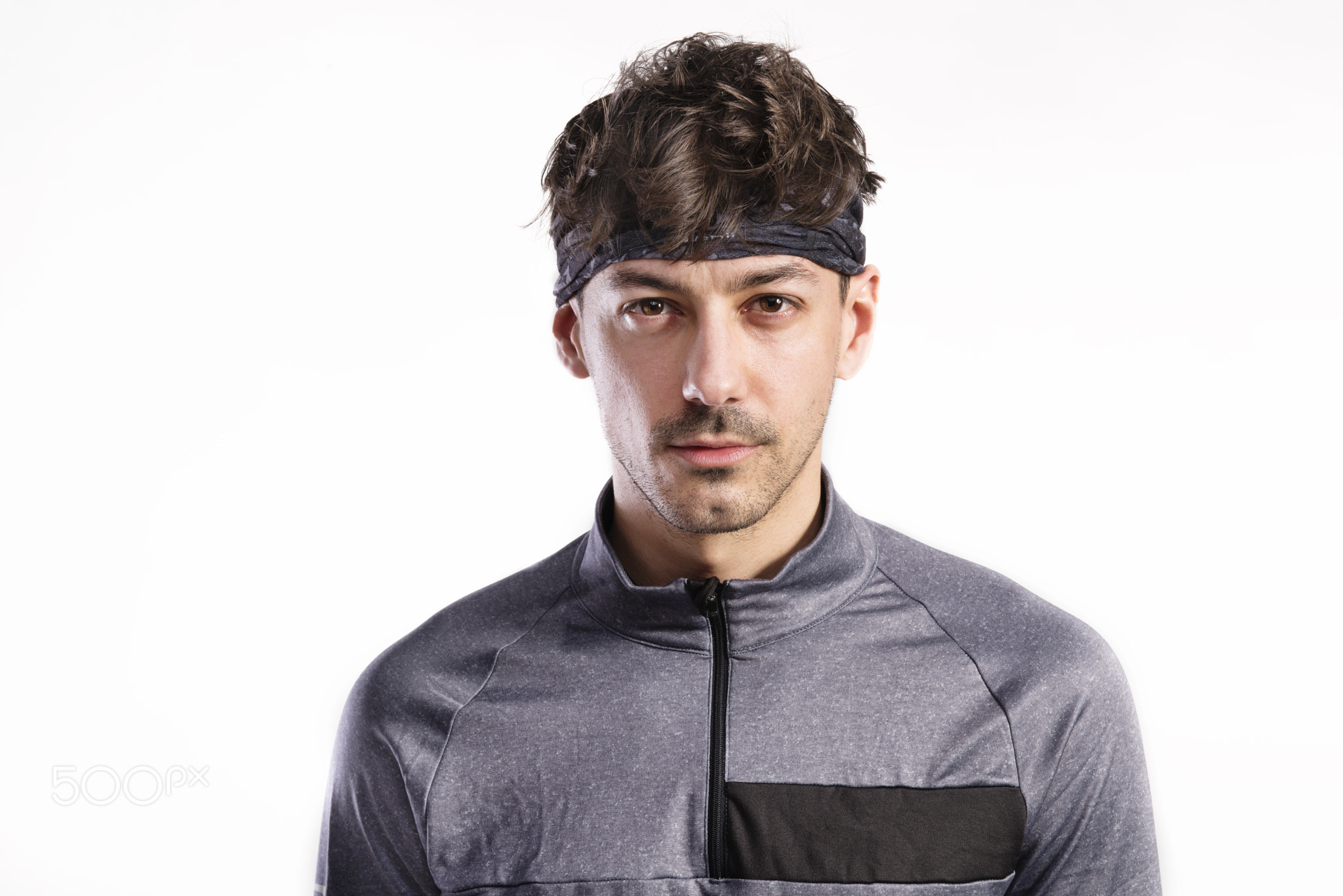 Handsome fitness man in gray sweatshirt, studio shot.