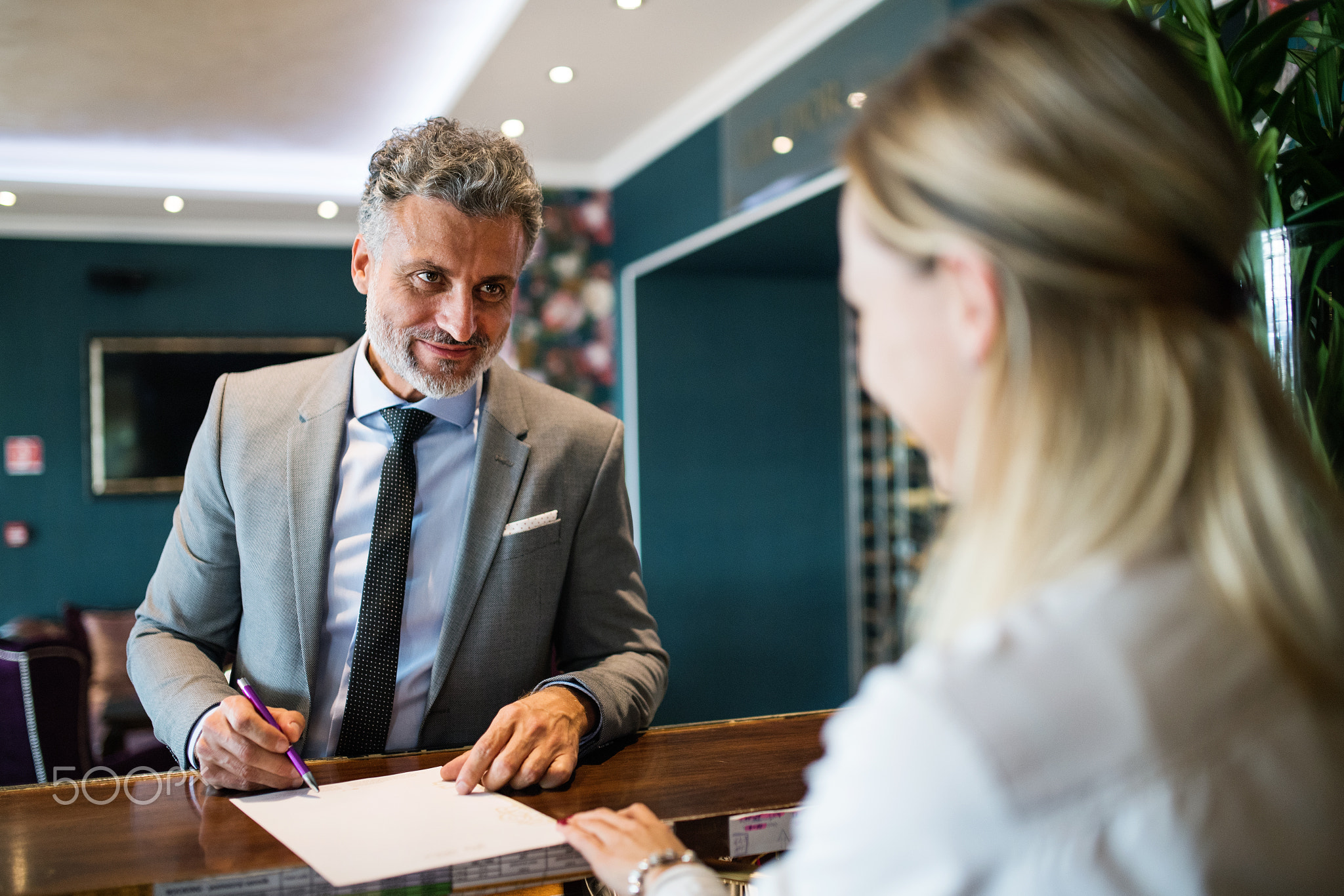 Mature businessman at hotel reception.