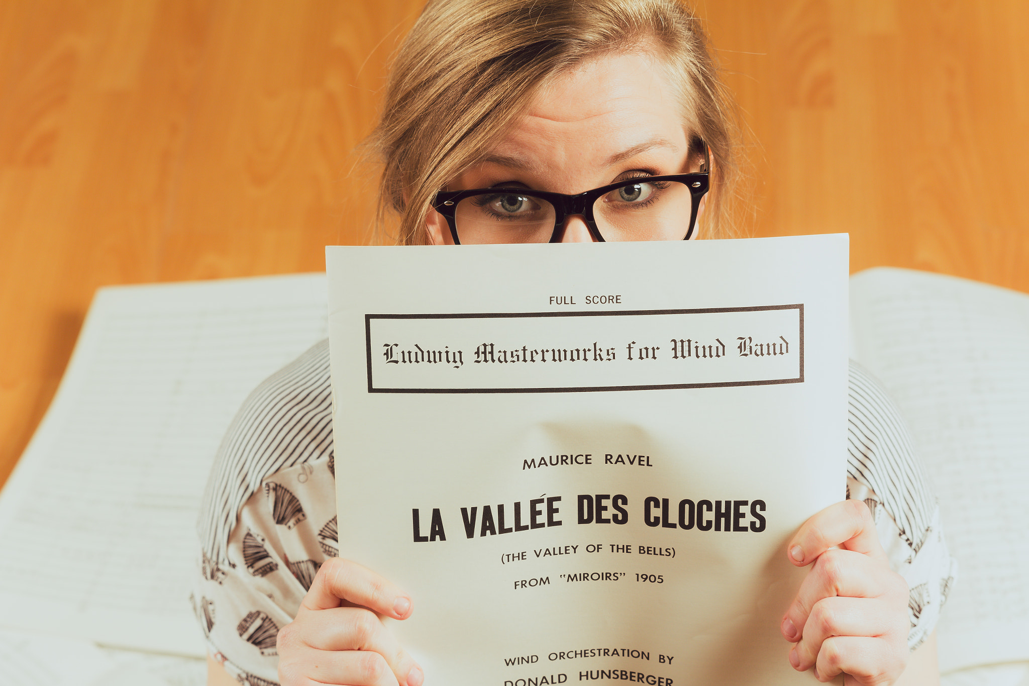 Young caucasian hipster woman with glasses with music shirt sits
