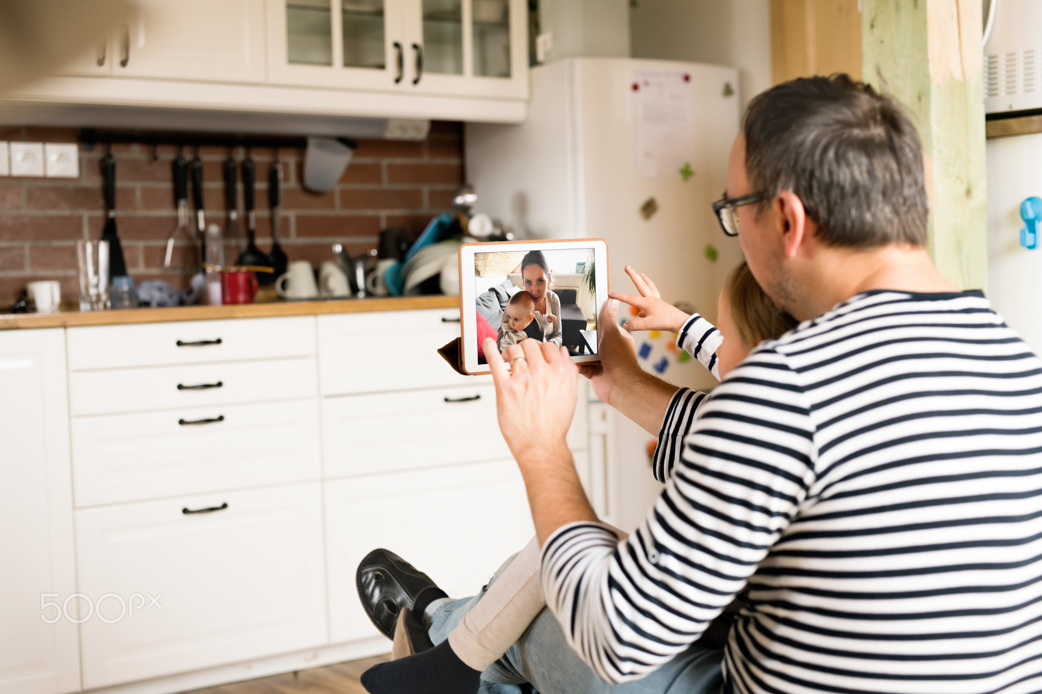 Young father videochatting with mother on tablet.