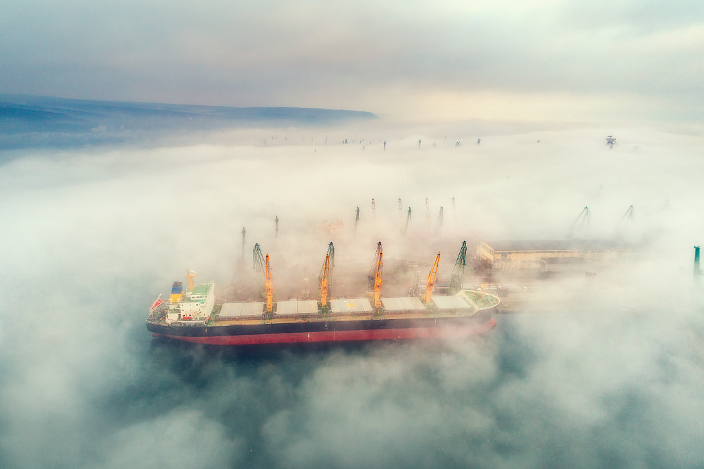 Industrial crane loading Containers in a Cargo freight ship by Valentin Valkov on 500px.com
