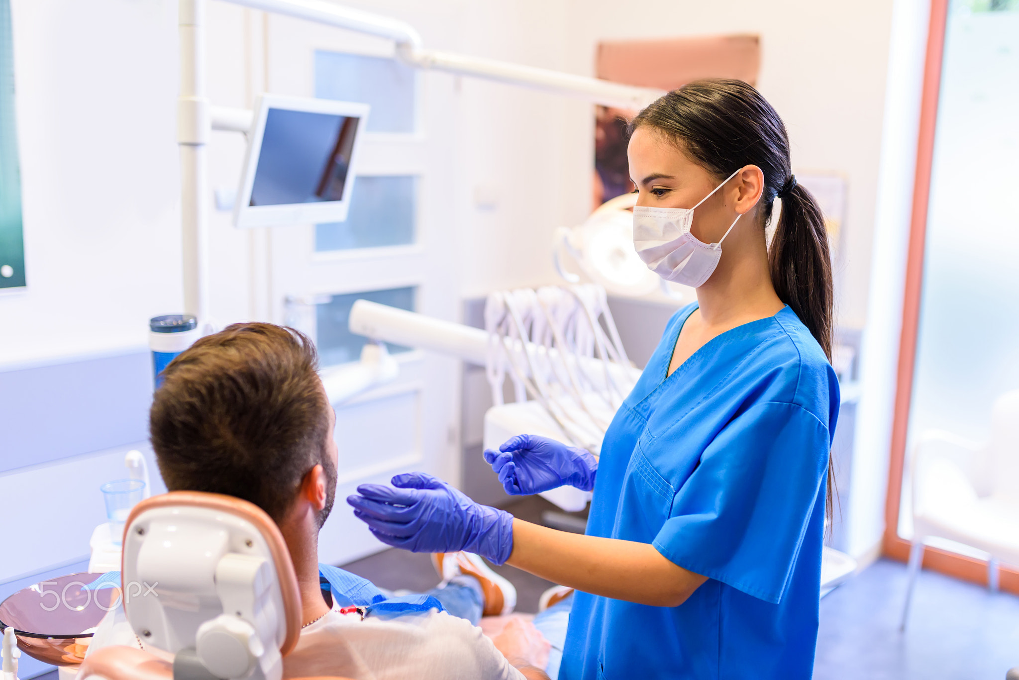 A female Dentist treating a patient in a dental practice