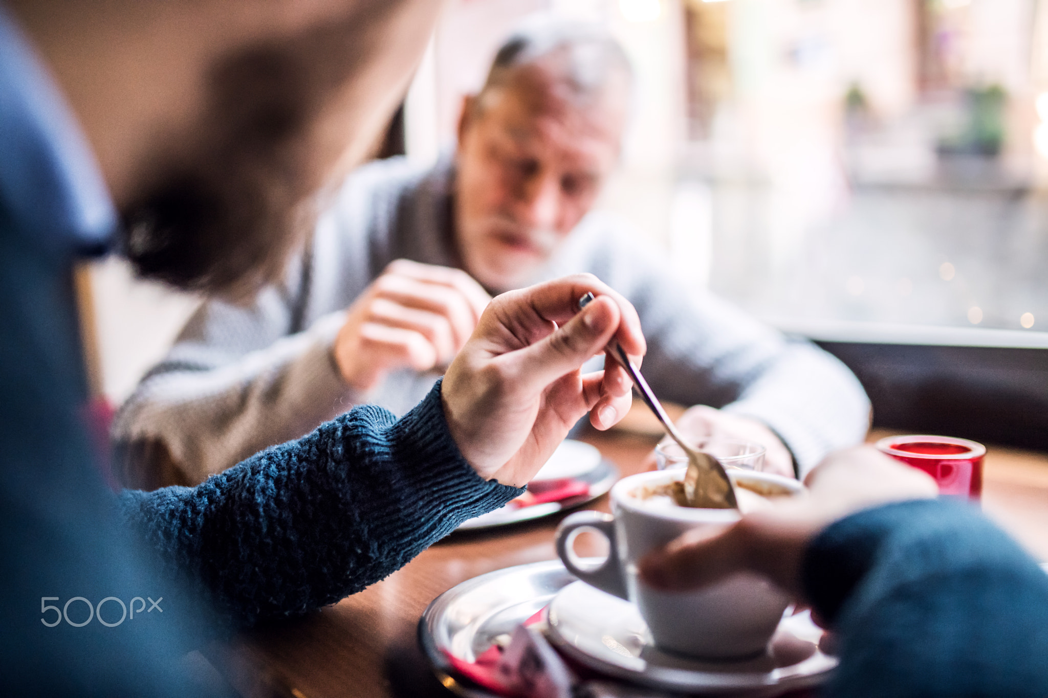 Senior father and his young son in a cafe.