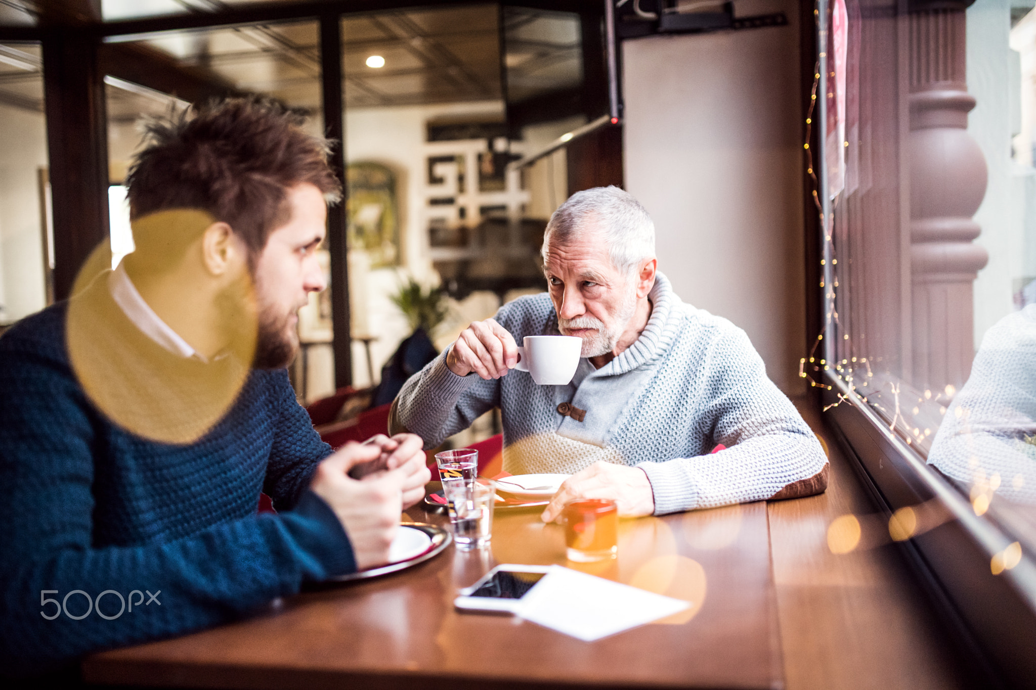 Senior father and his young son in a cafe.