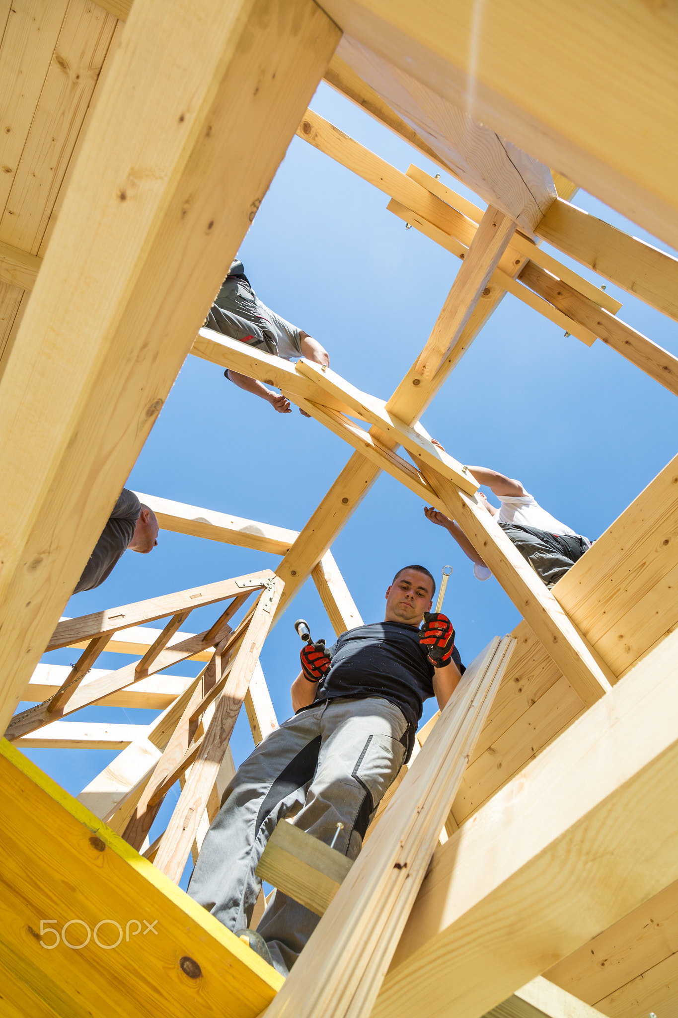 Builders at work with wooden roof construction.