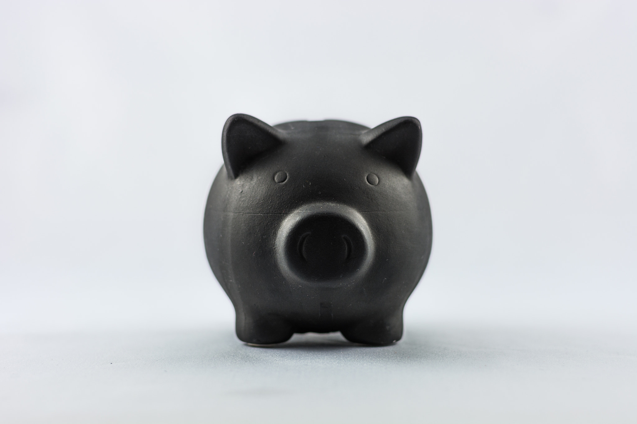 Black piggy bank on the white background