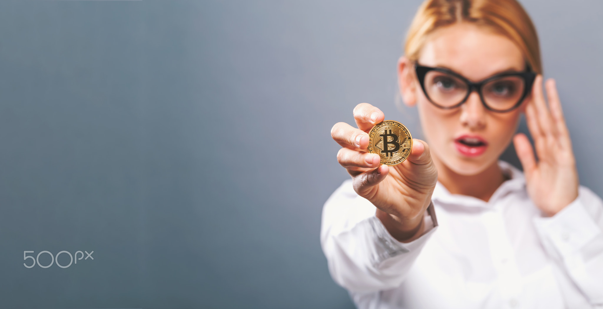 Woman holding a physical bitcoin