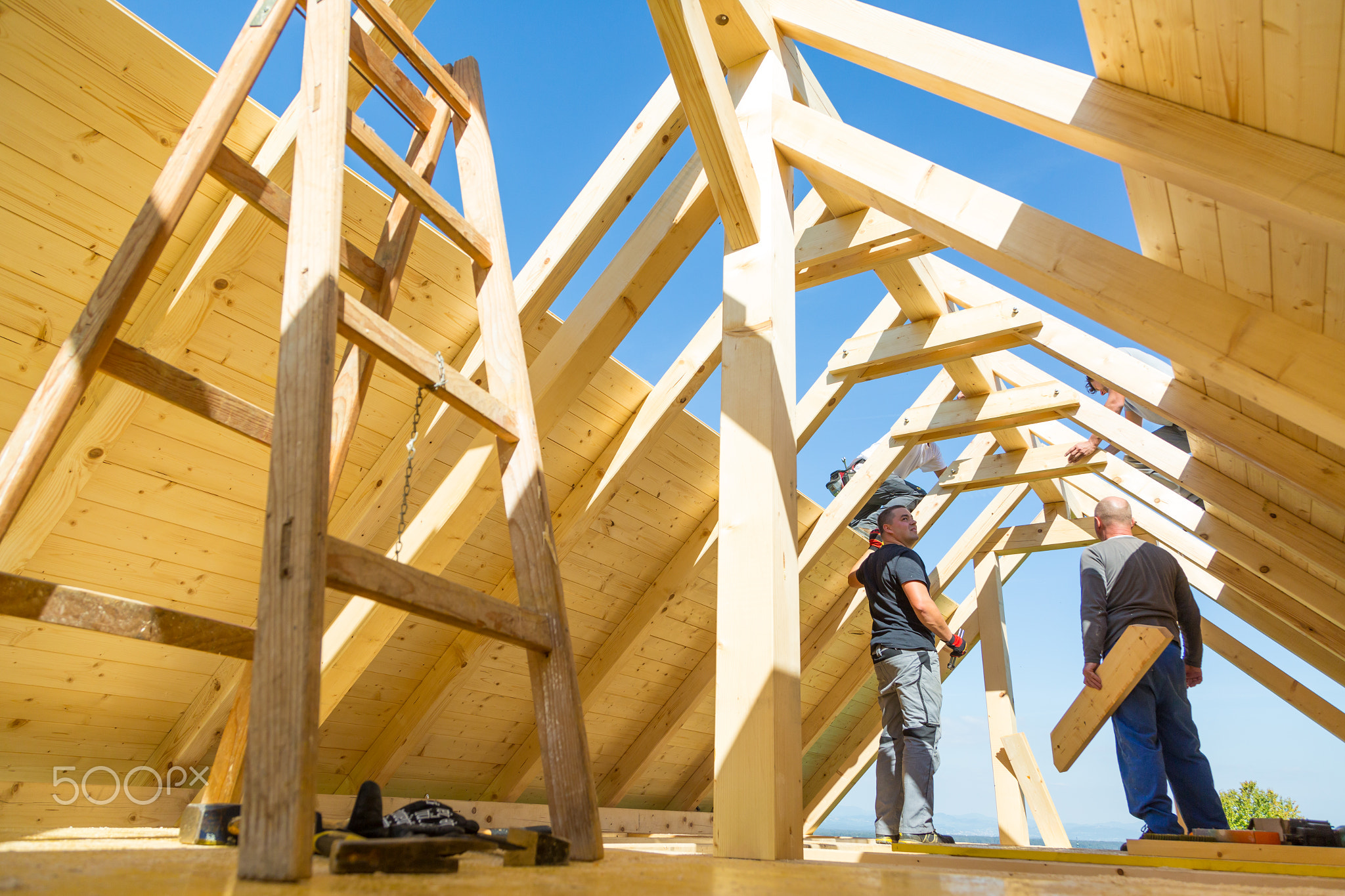 Builders at work with wooden roof construction.