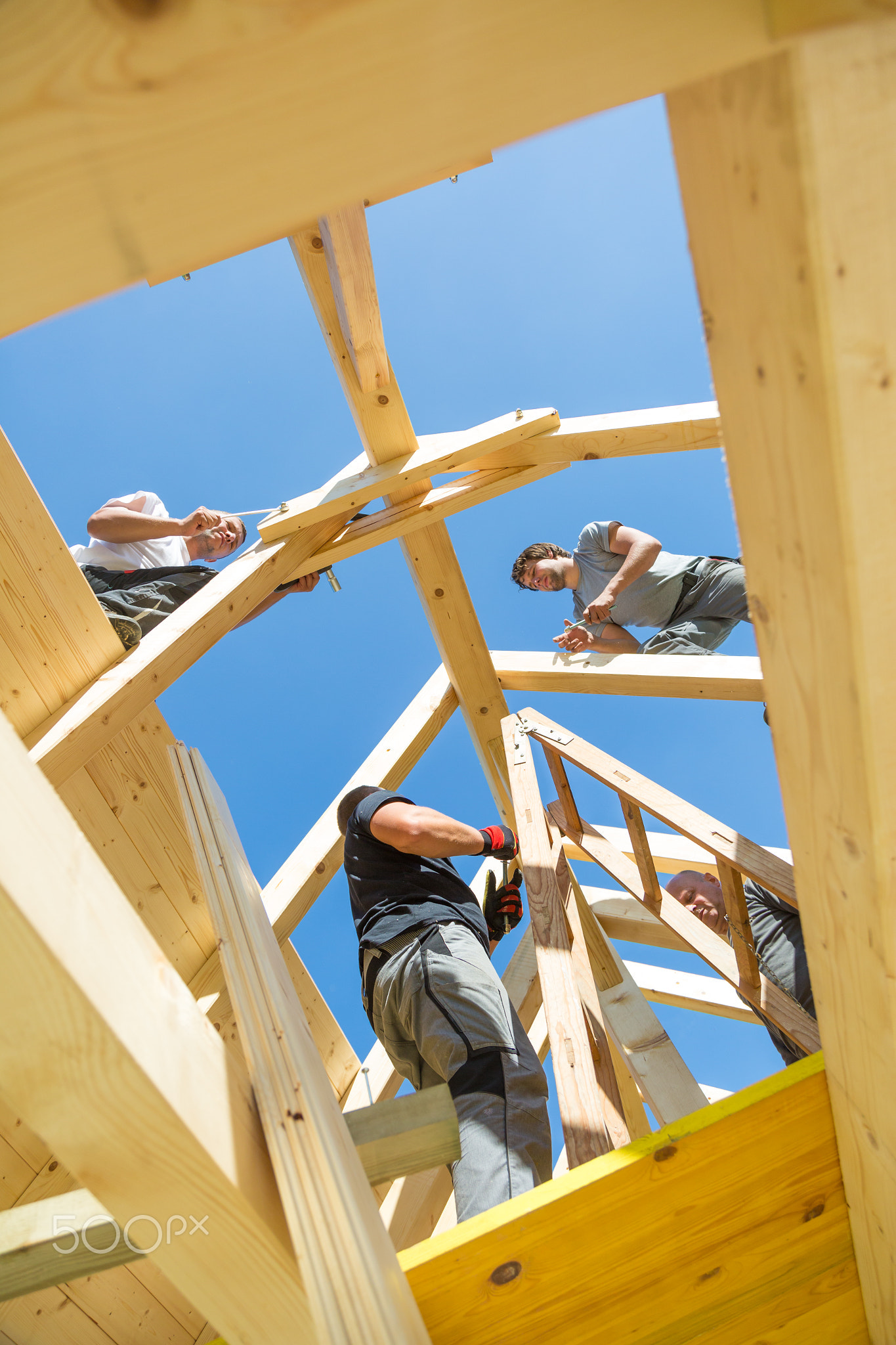 Builders at work with wooden roof construction.