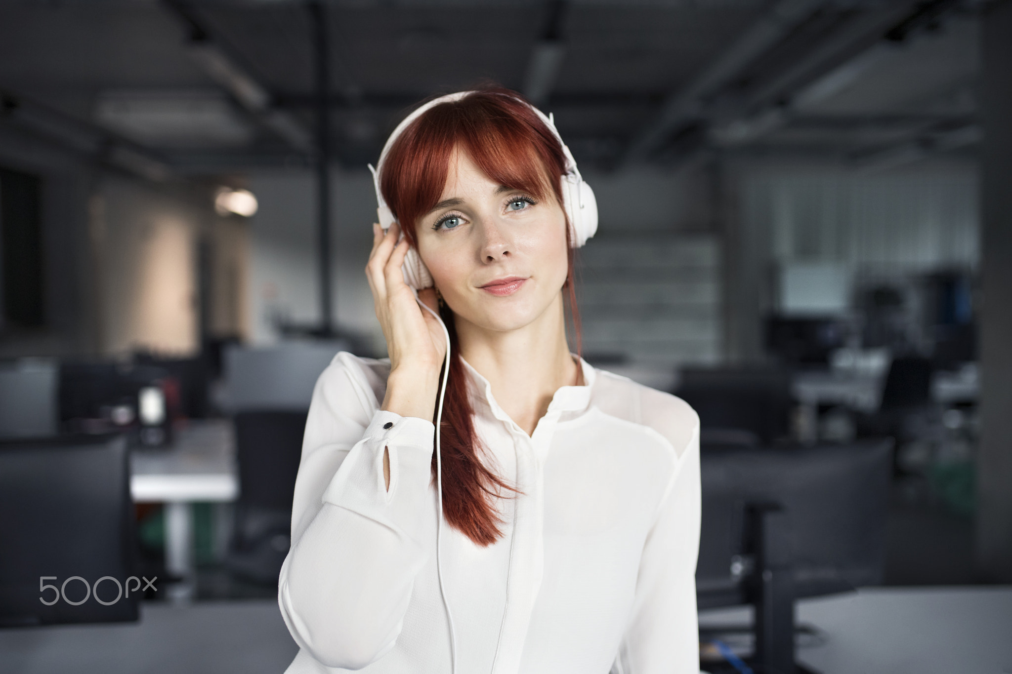 Businesswoman with big earphones in her office.