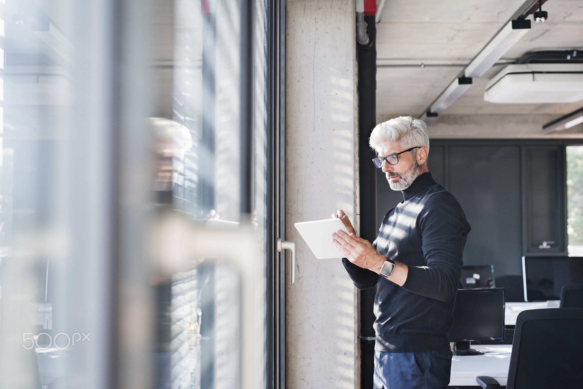 Mature businessman with tablet in the office.