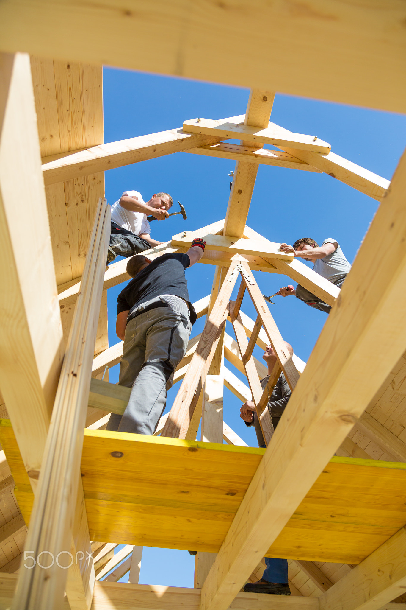 Builders at work with wooden roof construction.
