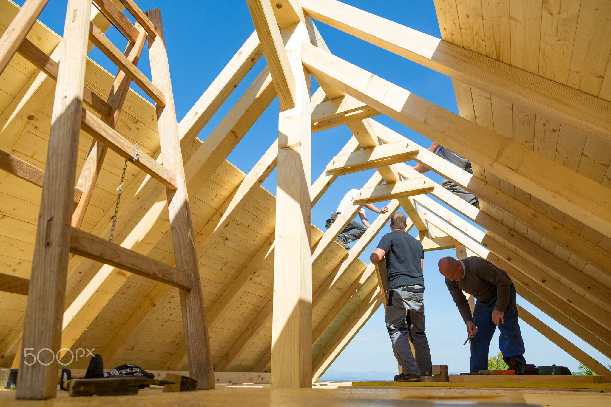 Builders at work with wooden roof construction.