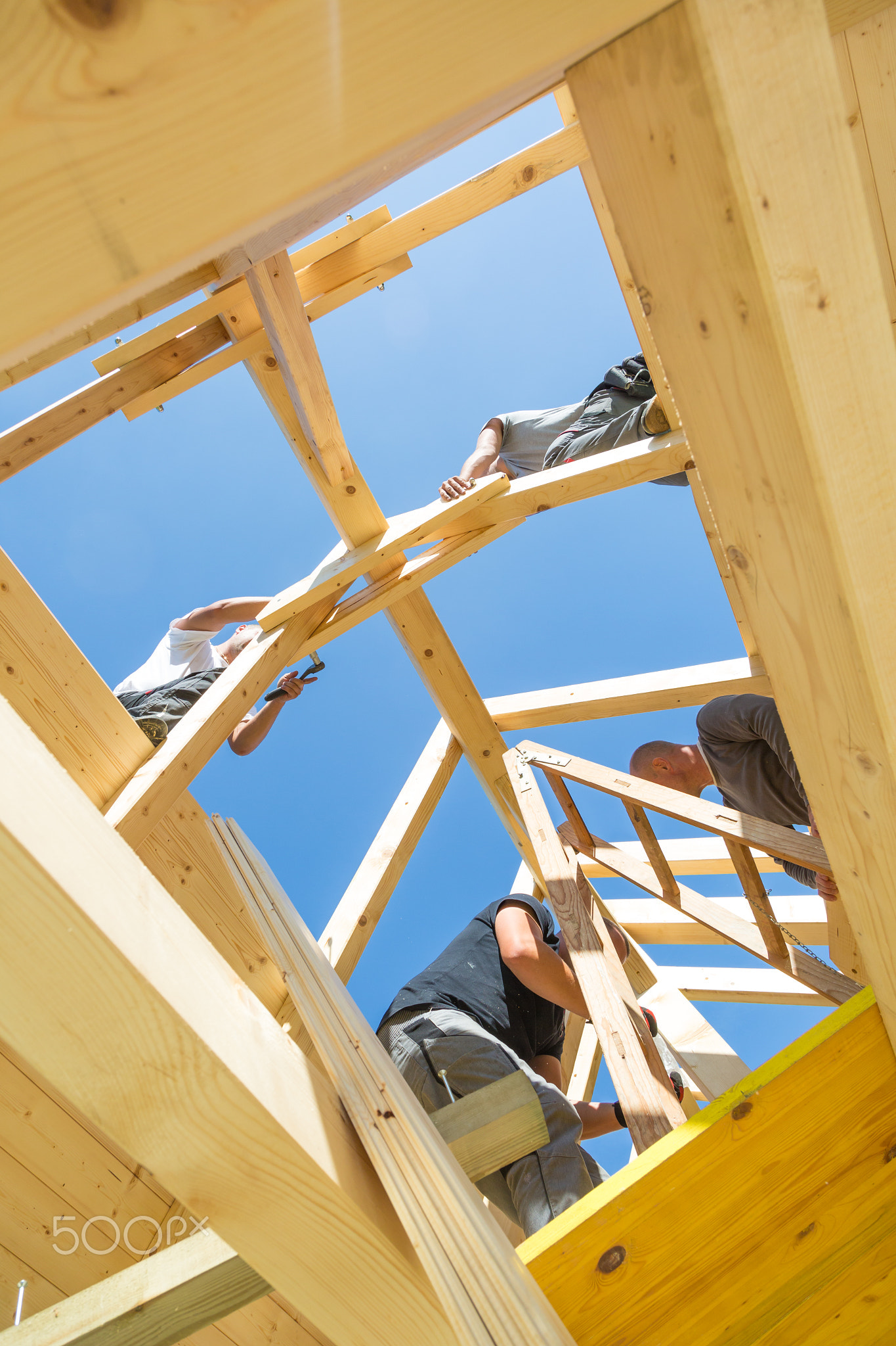 Builders at work with wooden roof construction.