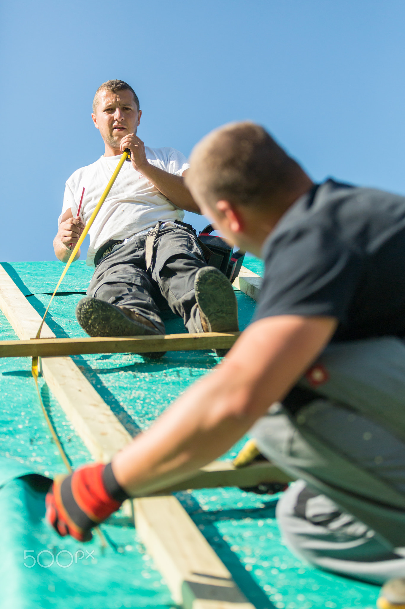 Builders at work with wooden roof construction.