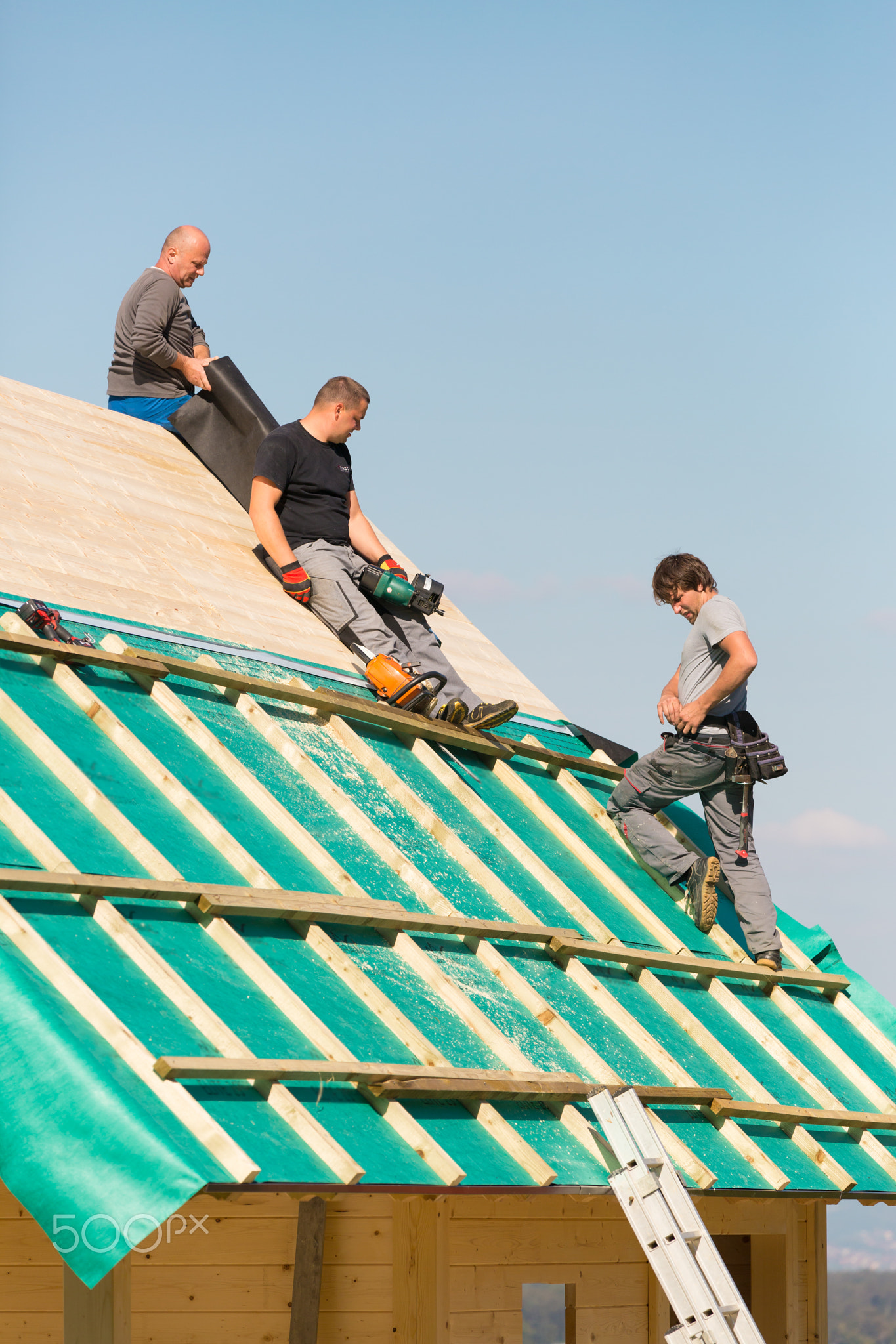 Builders at work with wooden roof construction.