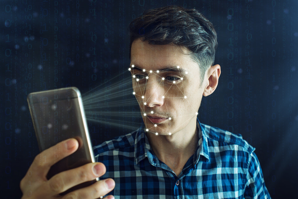 Man is trying to access the phone using the personal identification method of face recognition by Artem Oleshko on 500px.com