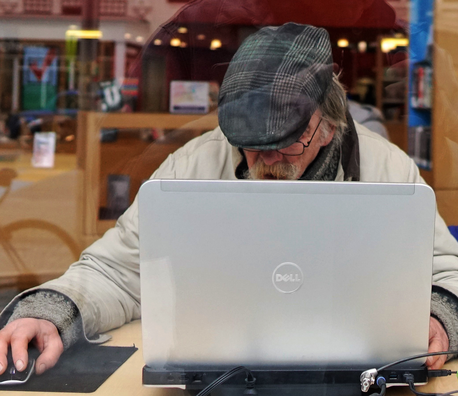 An old timer using his laptop at the window seats of thee Boston public Library
