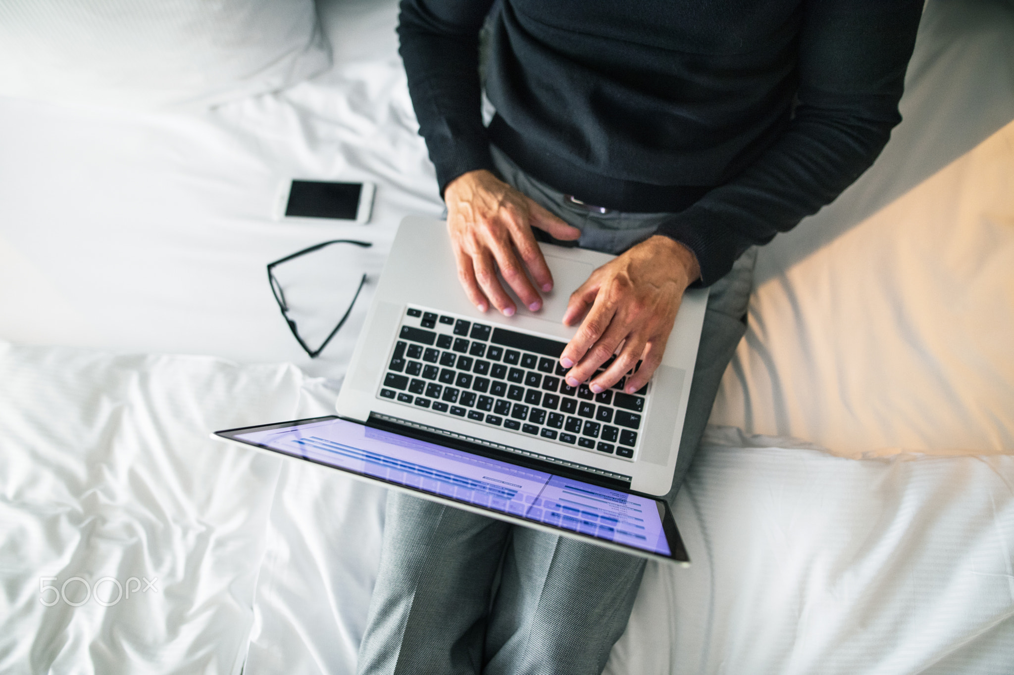 Mature businessman with laptop in a hotel room.