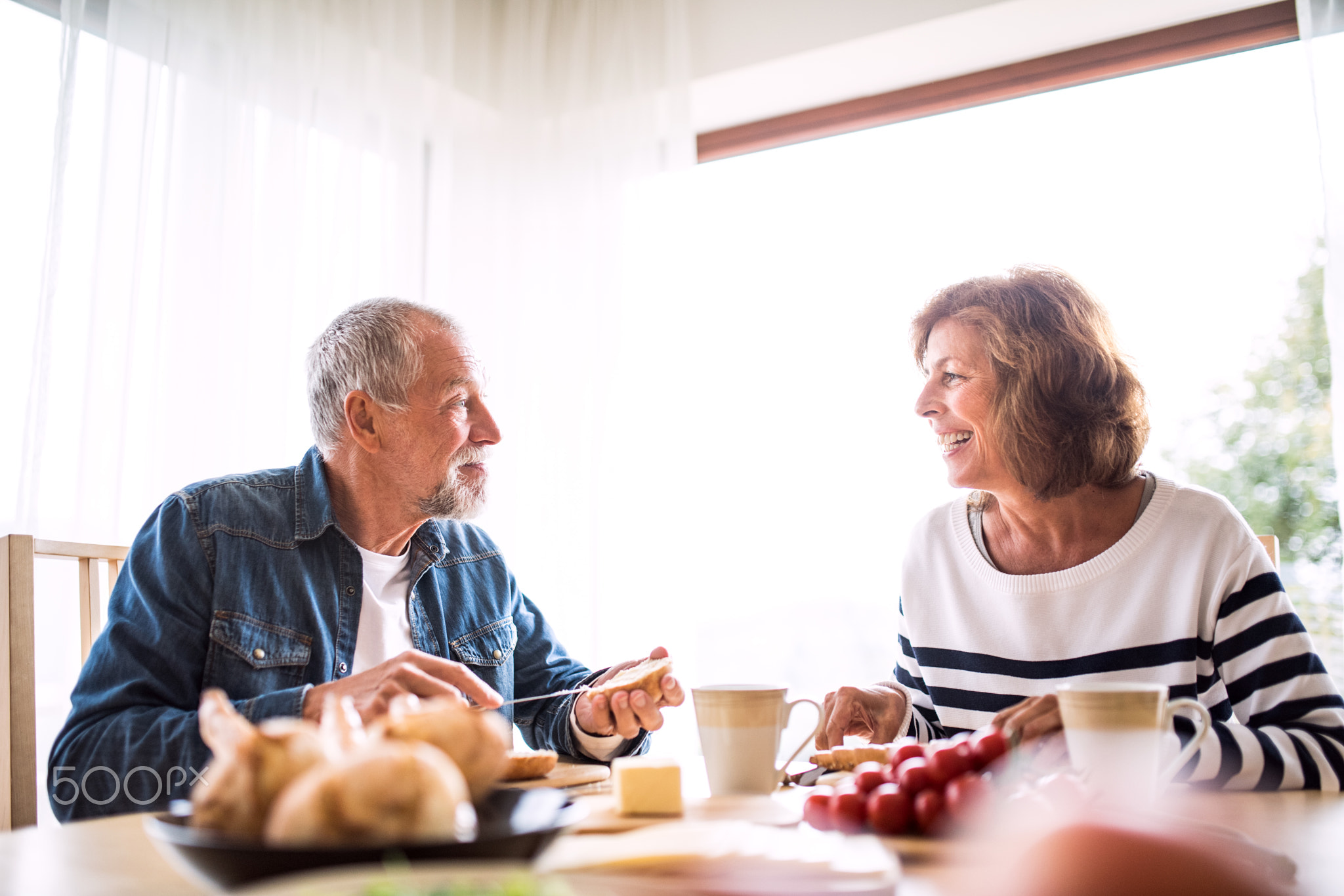 Senior couple eating breakfast at home.