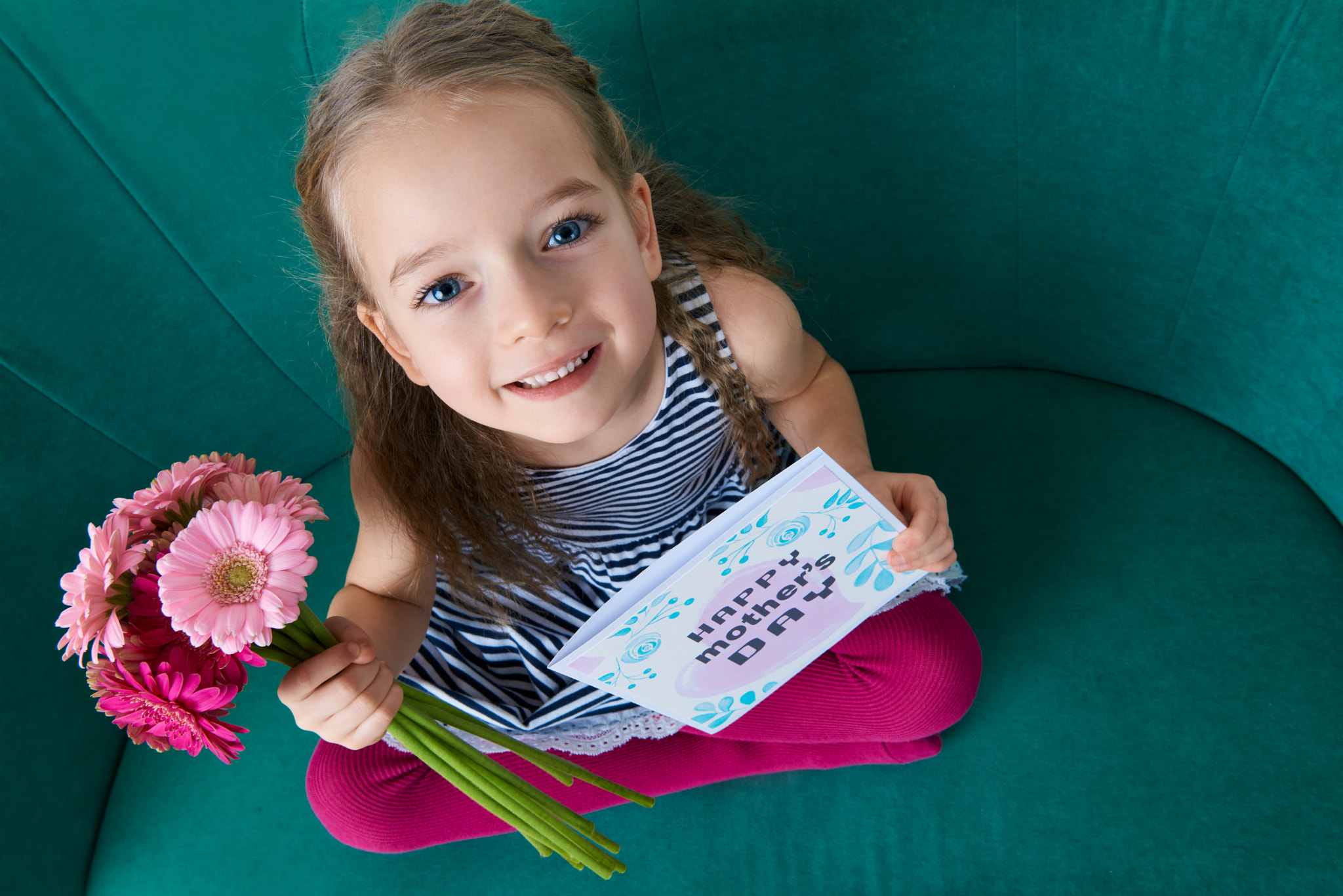 Nikon AF-S Nikkor 24-70mm F2.8G ED sample photo. Adorable young girl sitting on a couch, looking up and holding bouquet of pink gerbera daisies... photography