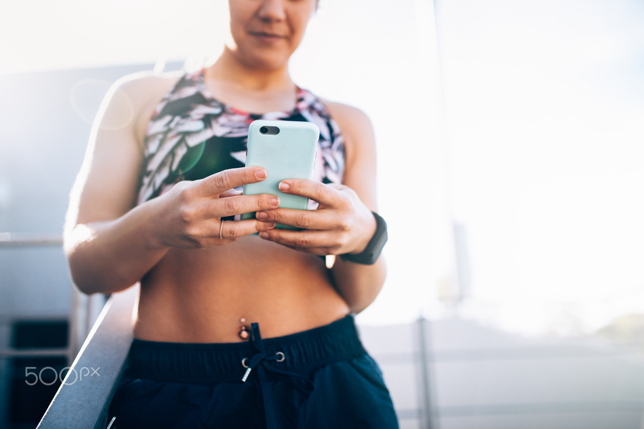 Close-up of fit muscular woman using smart phone to track workou