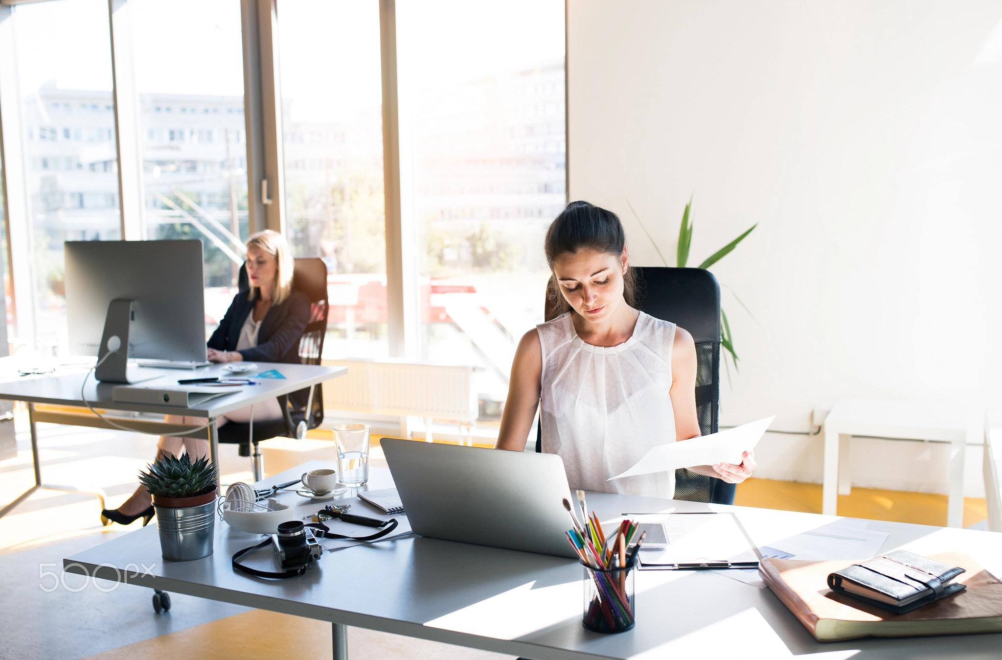 Two businesswomen in the office working together.