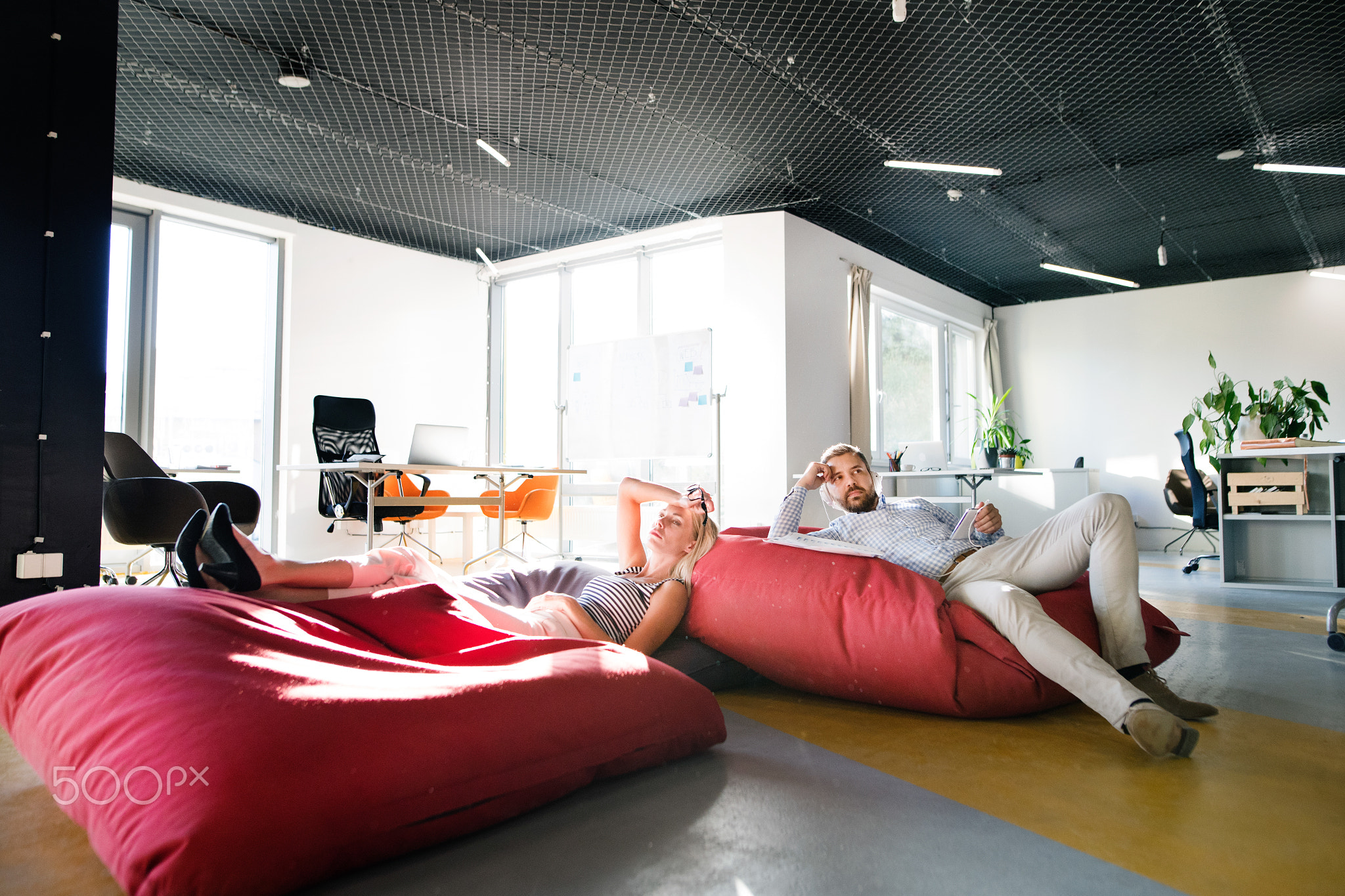 Business people in the office sitting in bean bags.