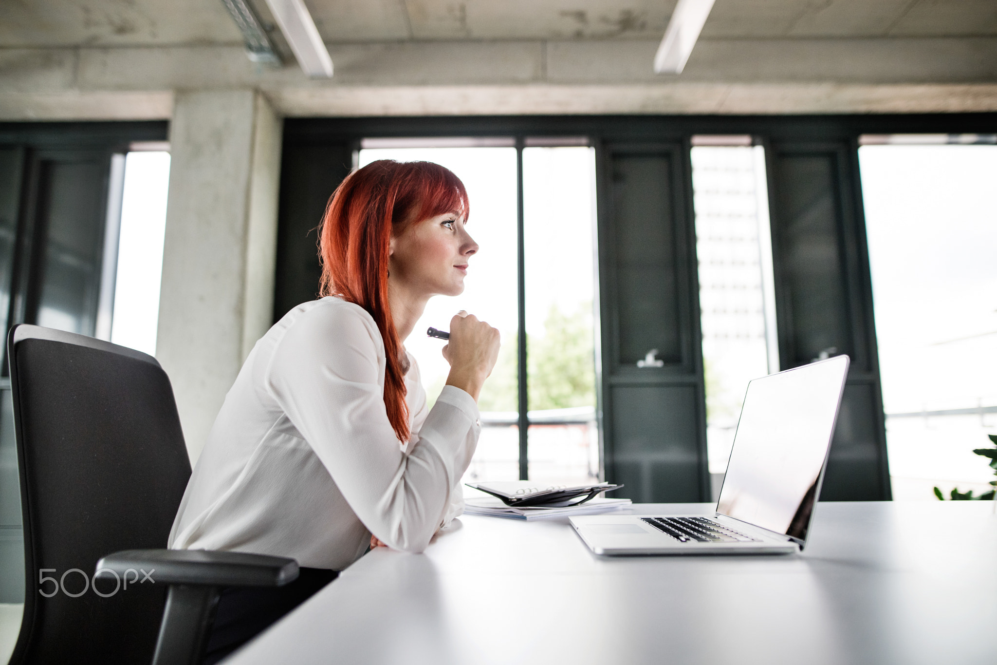 Businesswoman with laptop in her office.