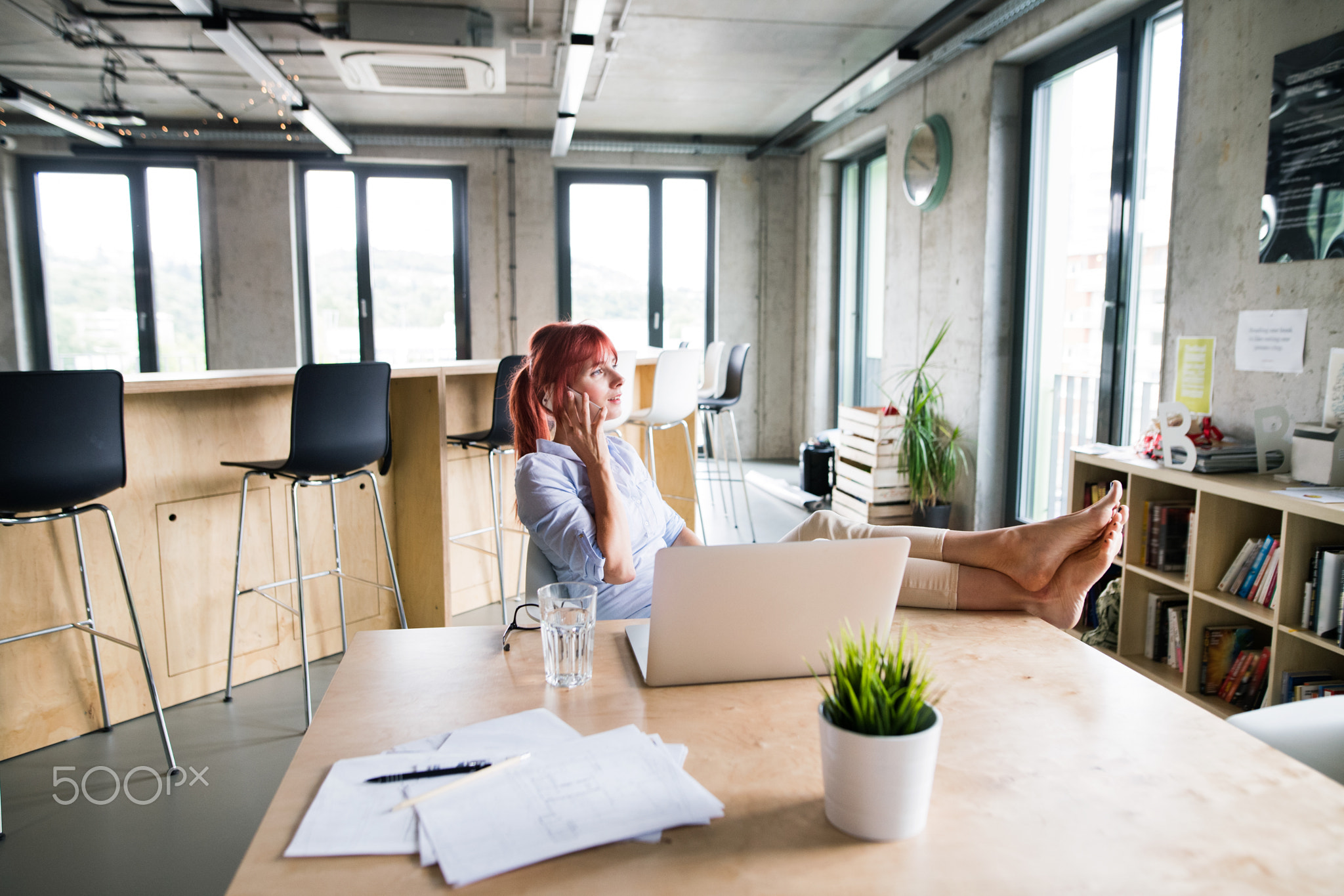 Businesswoman in her office, talking on the phone.