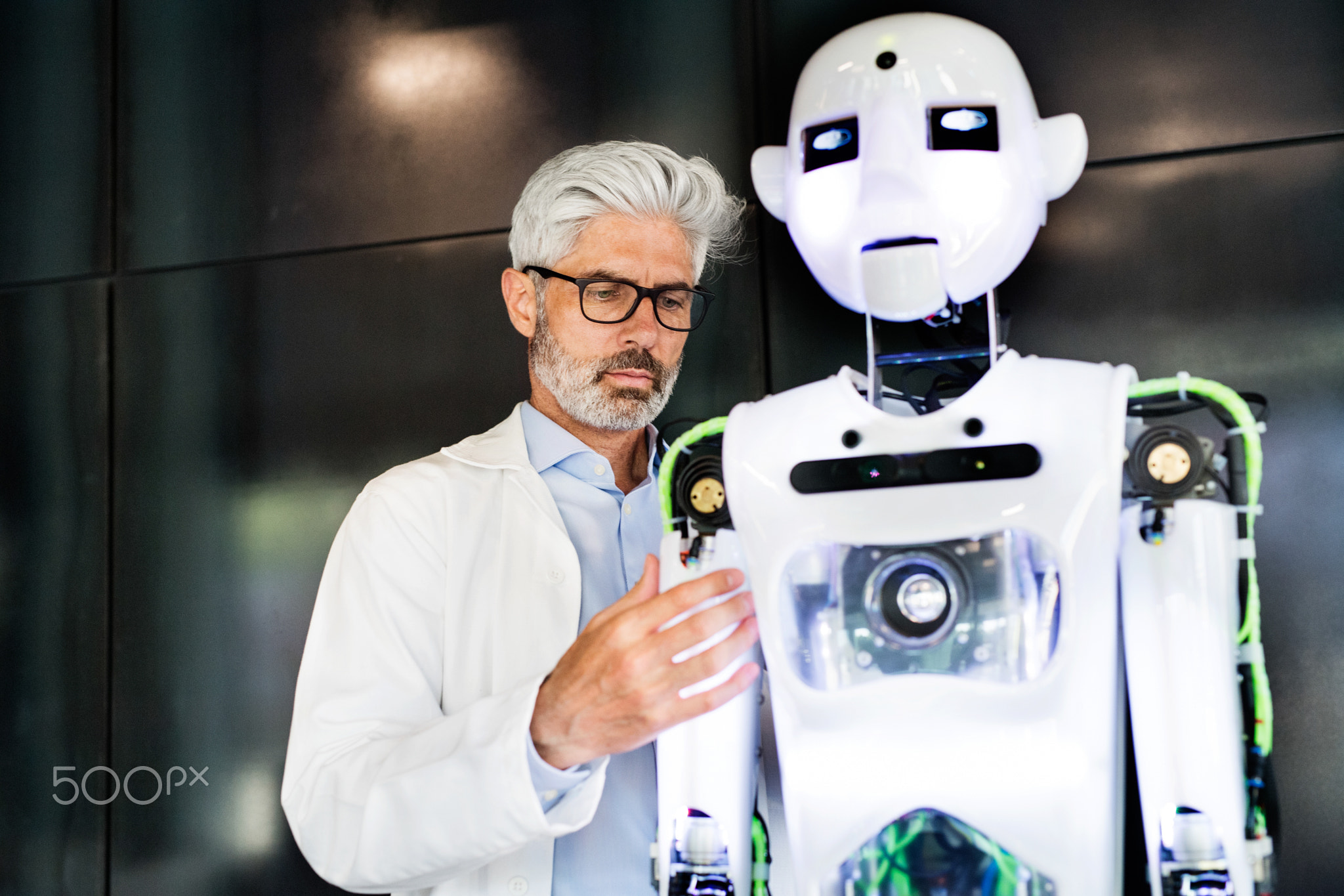 Mature businessman or a scientist with robot.