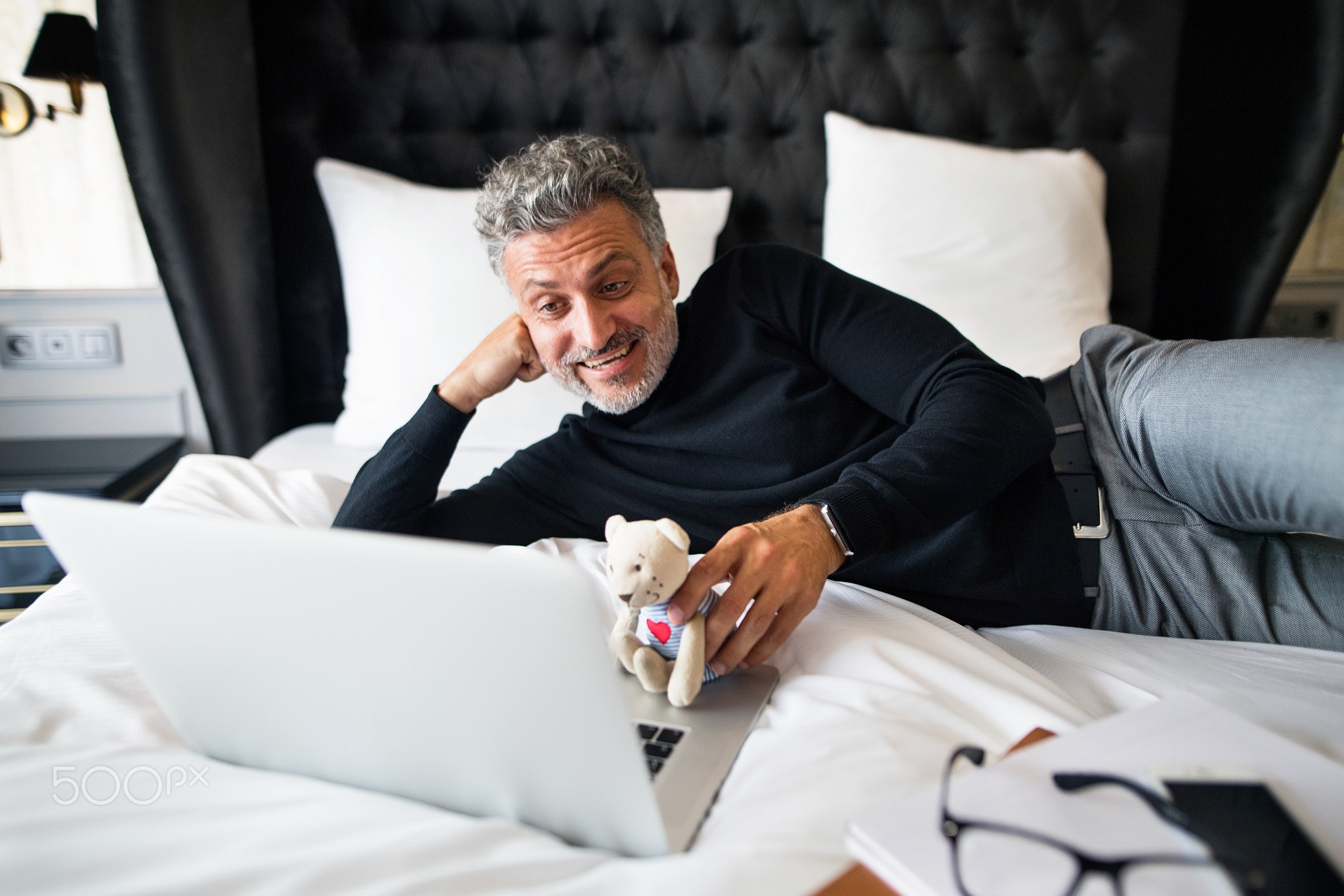Mature businessman with laptop in a hotel room.
