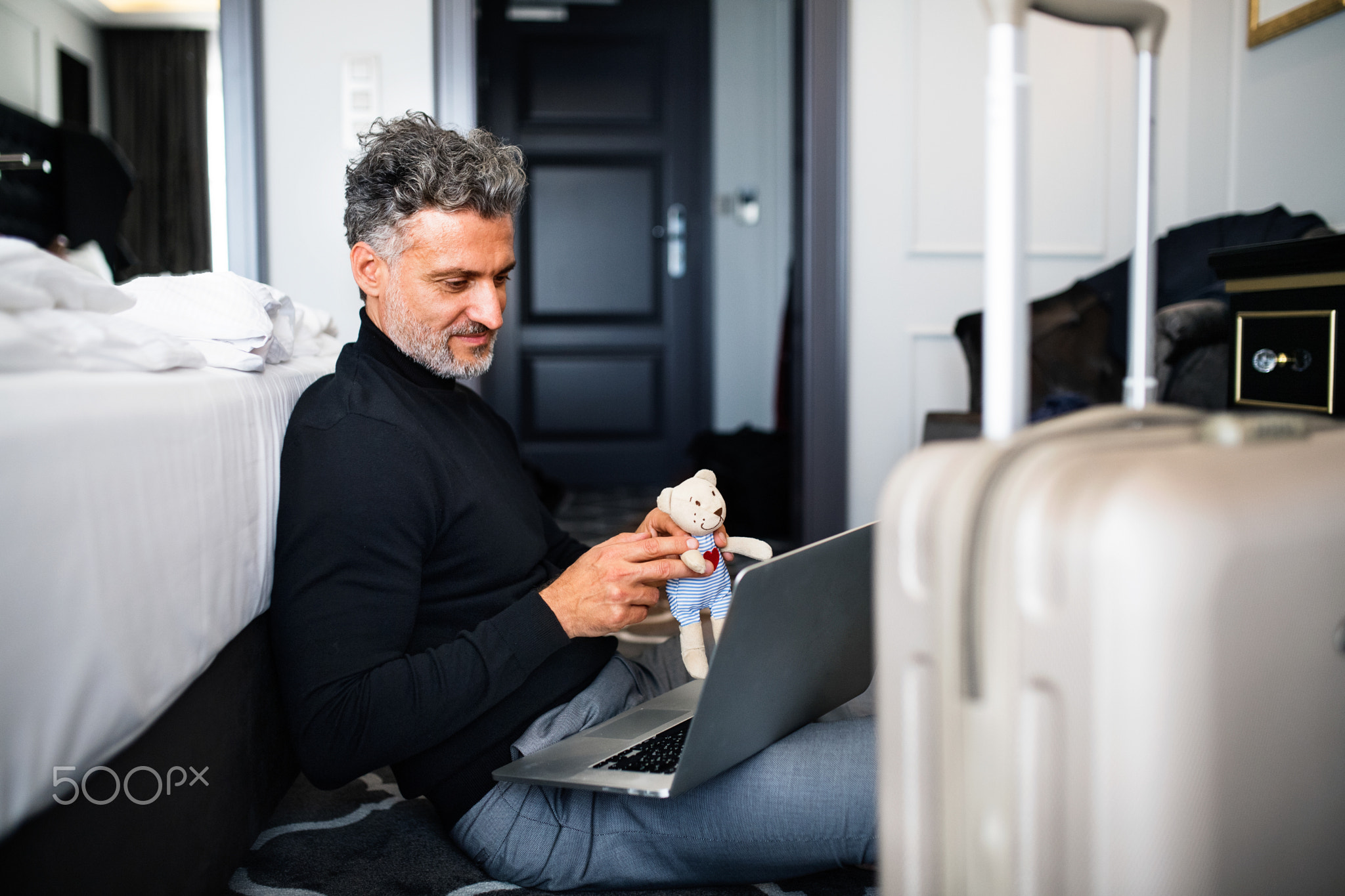 Mature businessman with laptop in a hotel room.