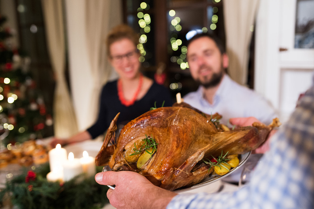 Family celebrating Christmas. Roasted turkey on tray. by Jozef Polc on 500px.com