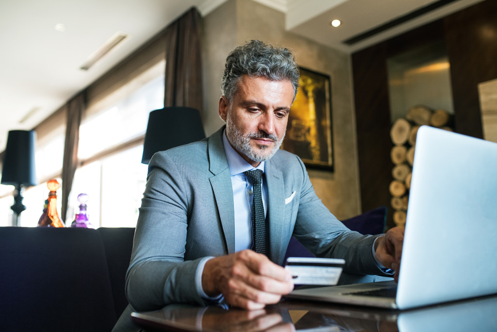 Mature businessman with laptop in a hotel lounge. by Jozef Polc on 500px.com