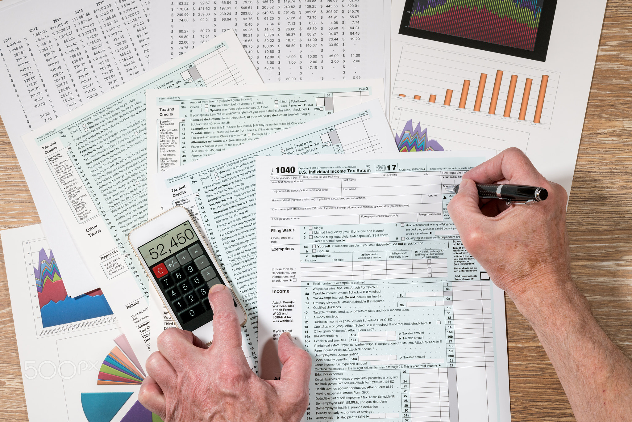 From above view of 2017 IRS form 1040 on wooden desk