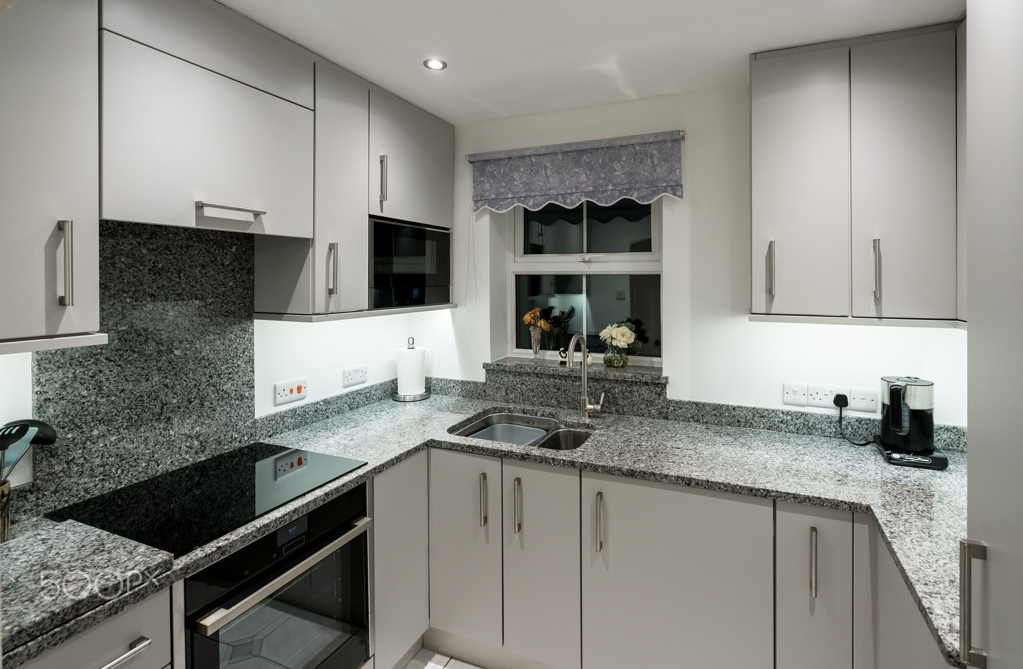 Small modern kitchen in apartment with granite worktop