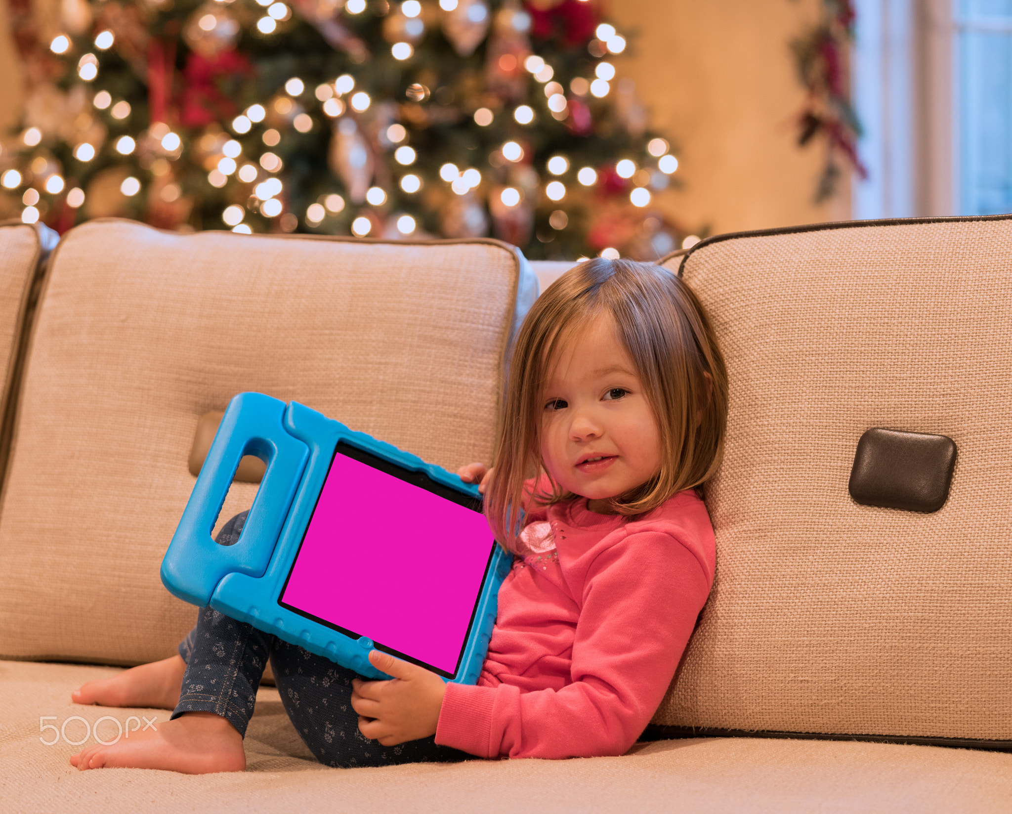 Preschool girl using a tablet computer at home at Christmas