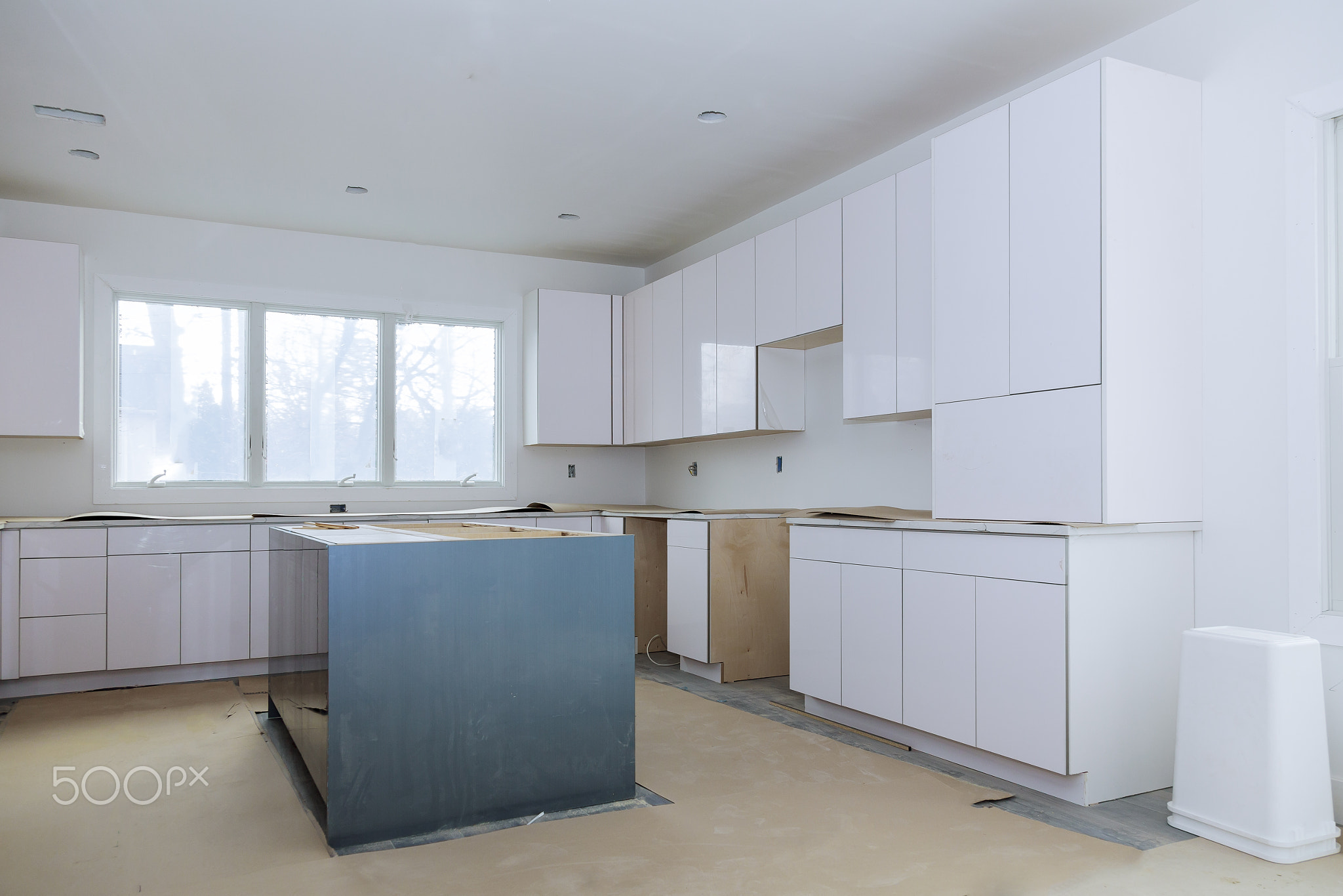 Custom kitchen cabinets in various stages of installation base for island in center