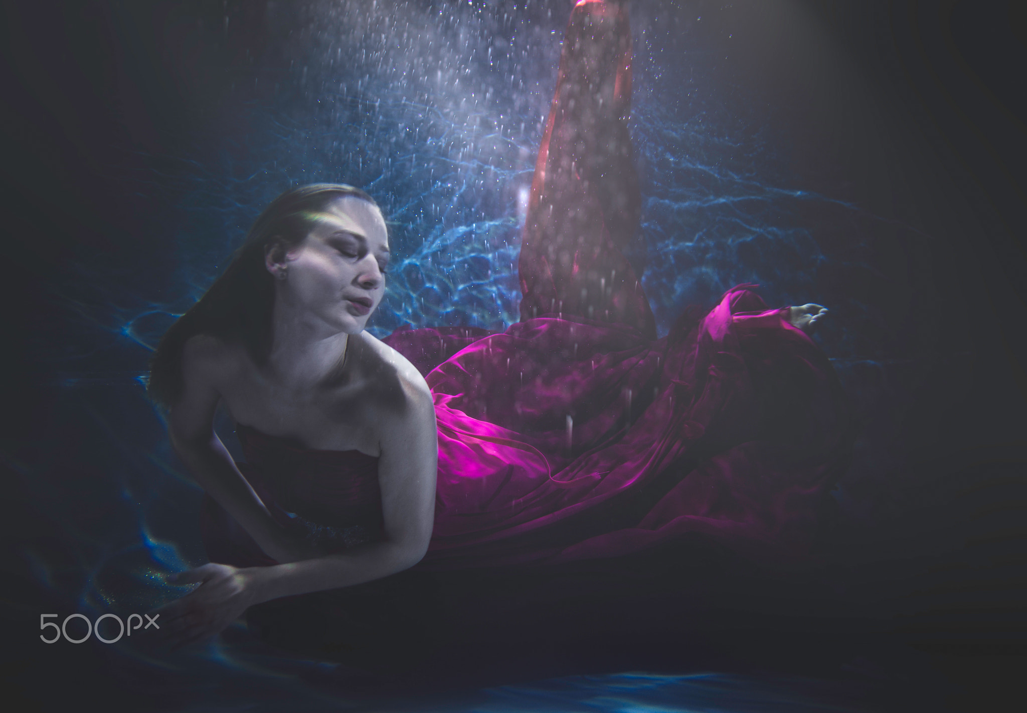 Beautiful woman swimming with fancy dress underwater