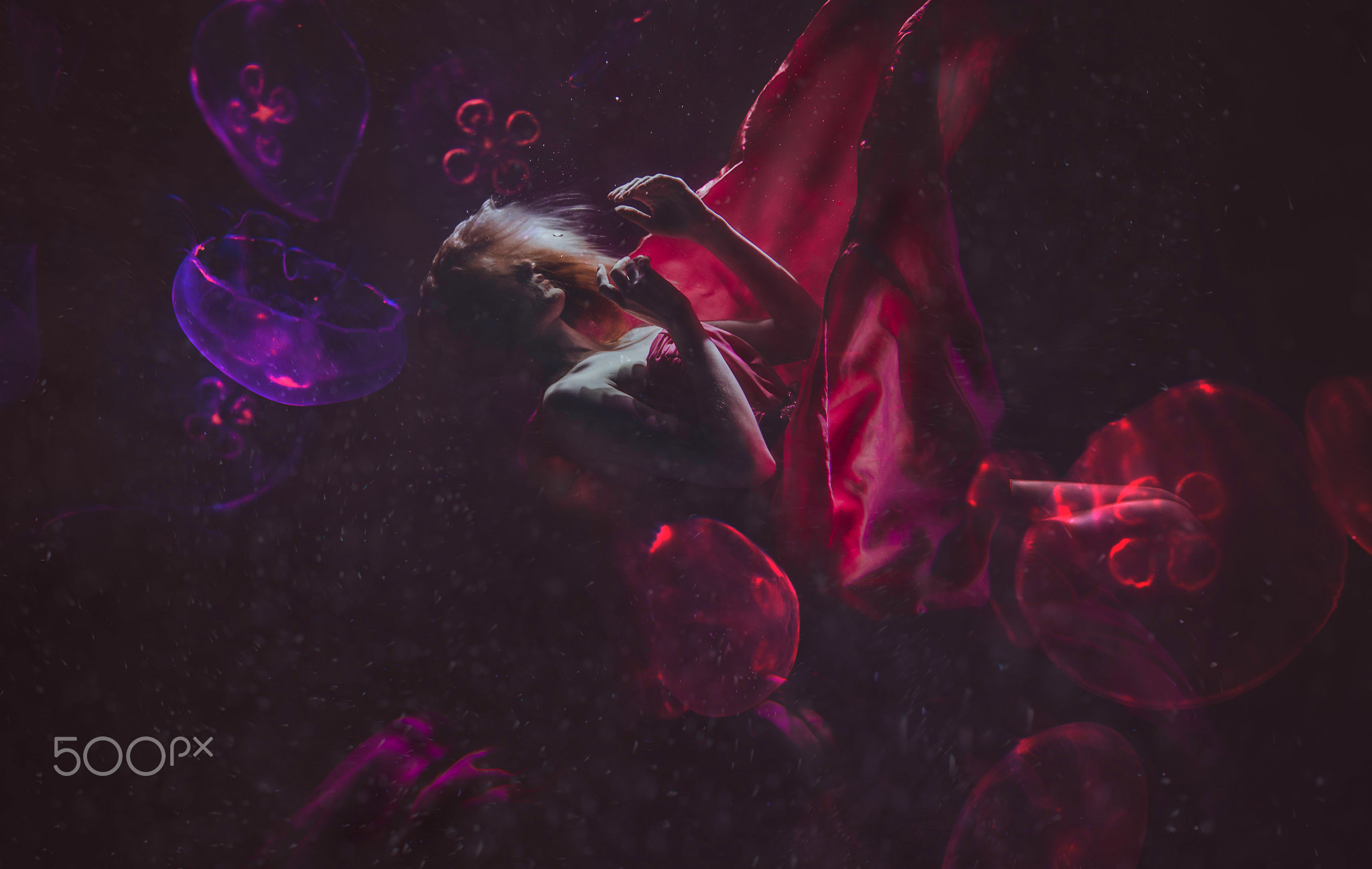 Beautiful woman swimming with fancy dress underwater