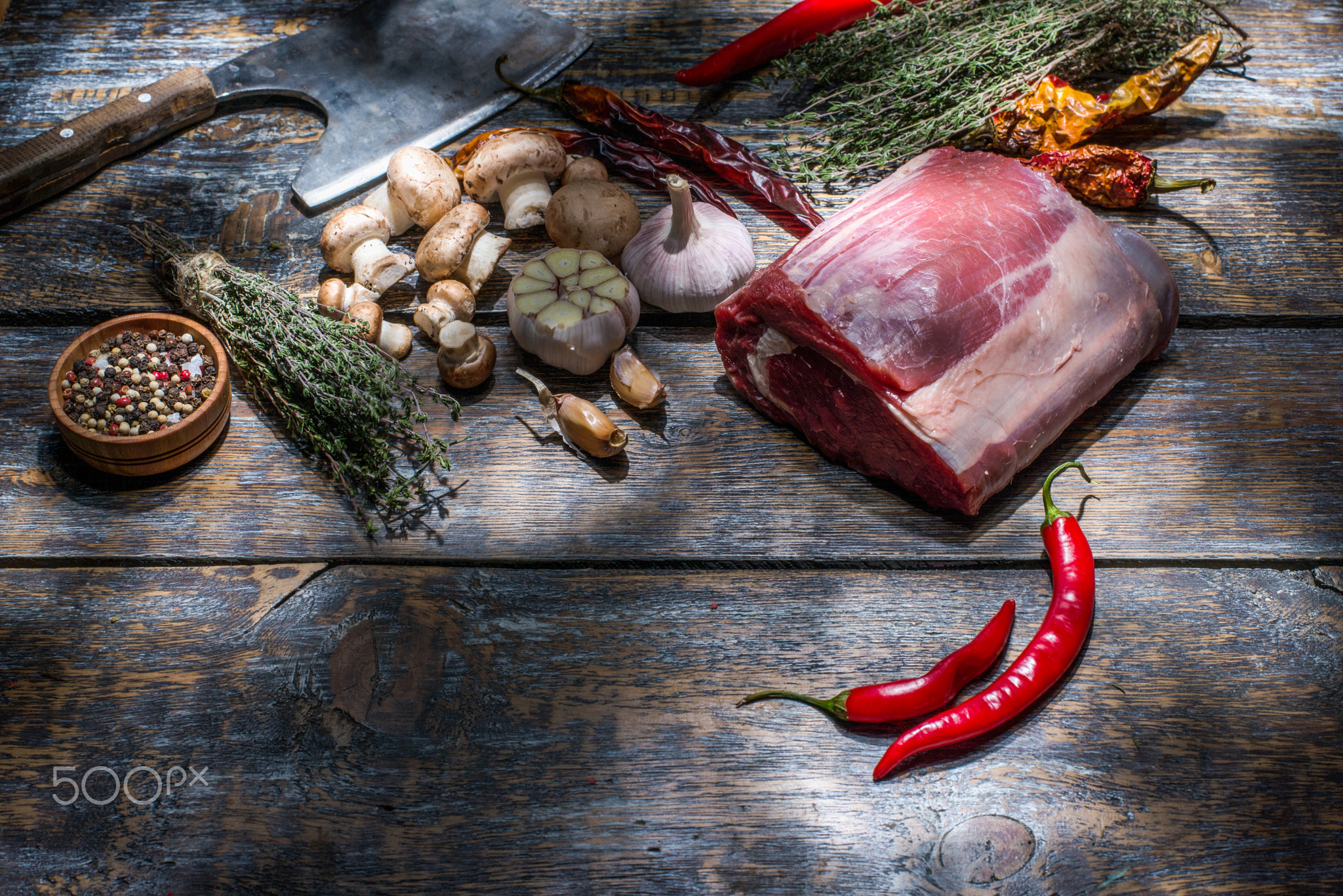 Raw Beef Steak, salt, pepper, garlic, rosemary  on the black board, background.