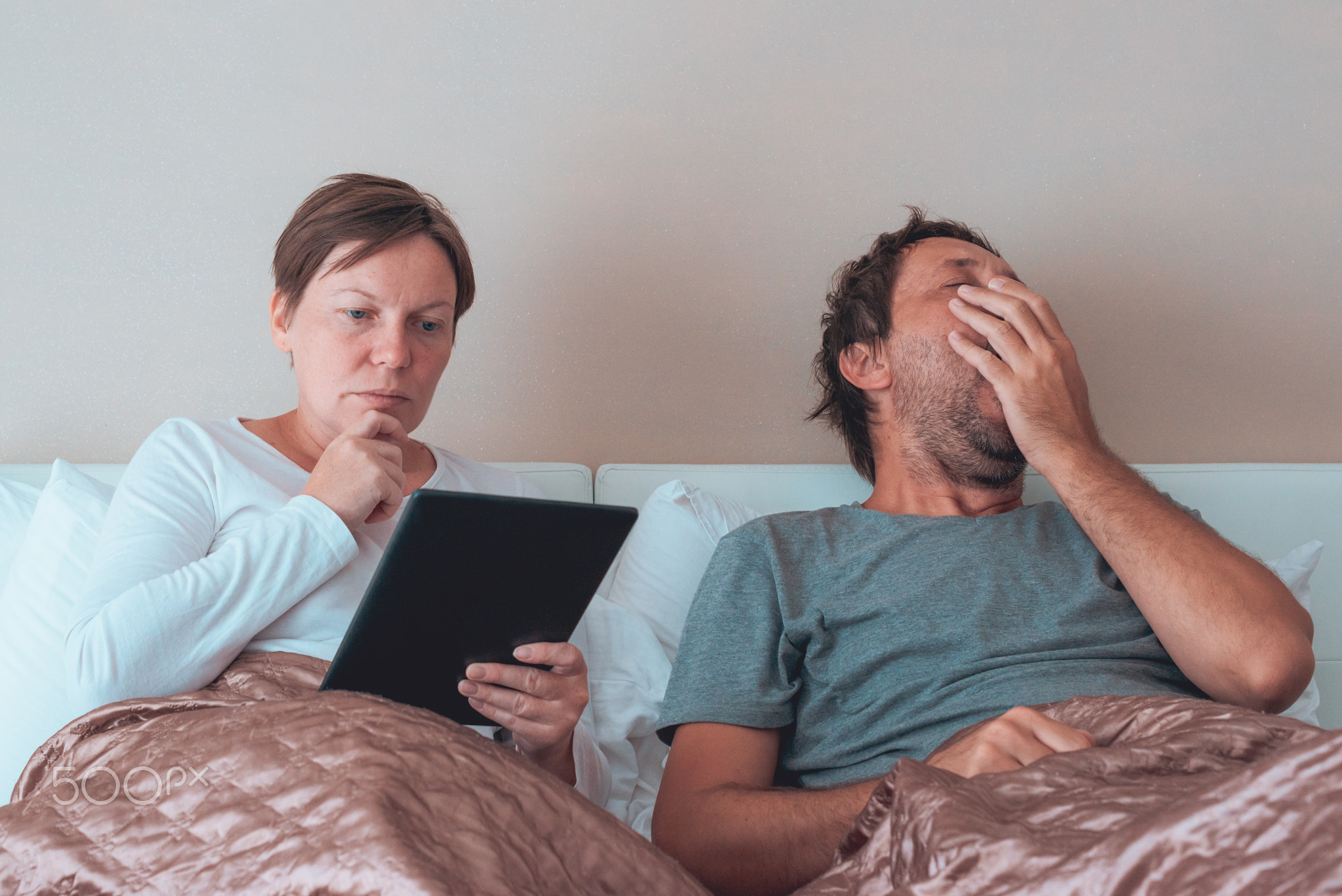Bored couple, husband and wife in bedroom