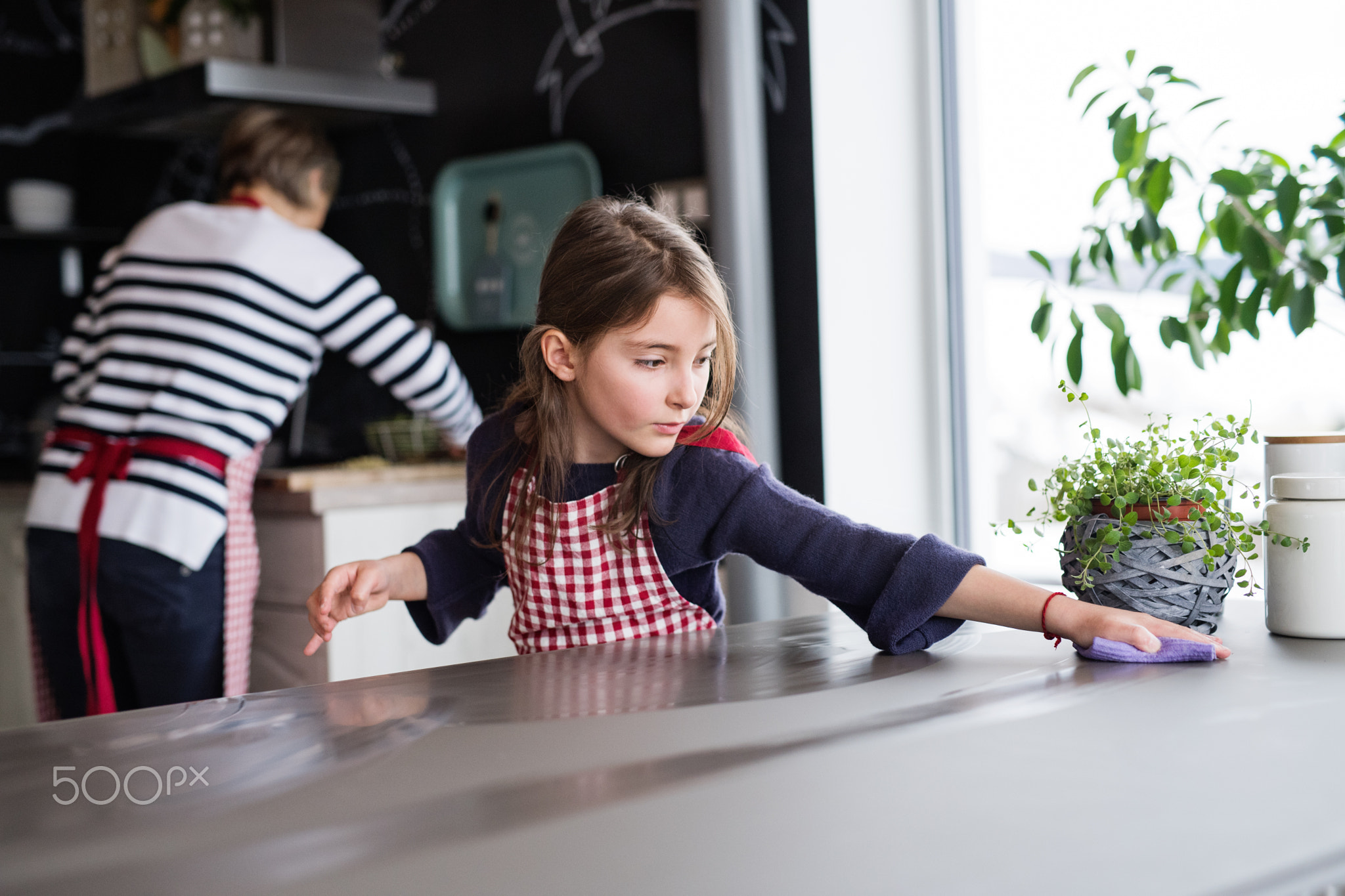 A small girl cooking with grandmother at home.