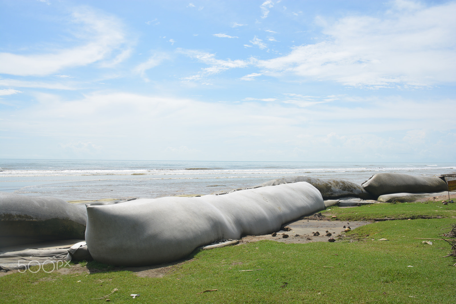 Nikon D5200 sample photo. Sea under cloudy sky with a green surface beach photography