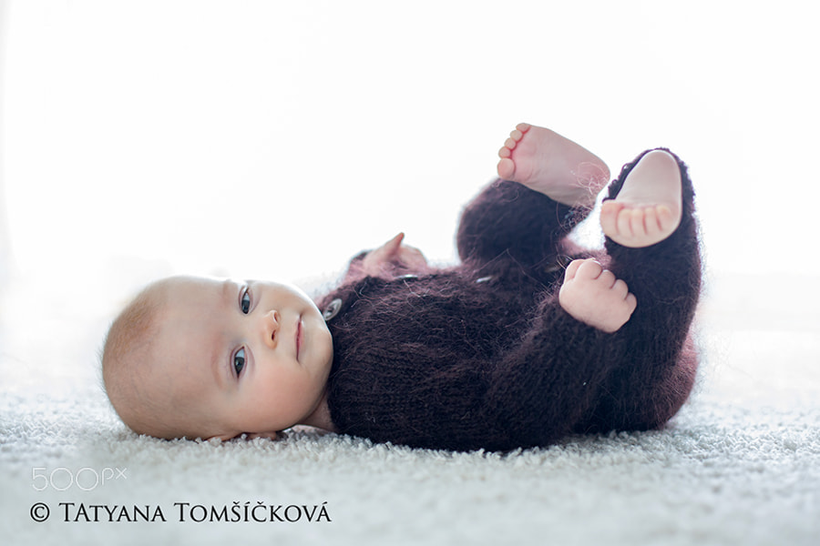 Little cute baby boy, dressed in handmade knitted brown teddy be
