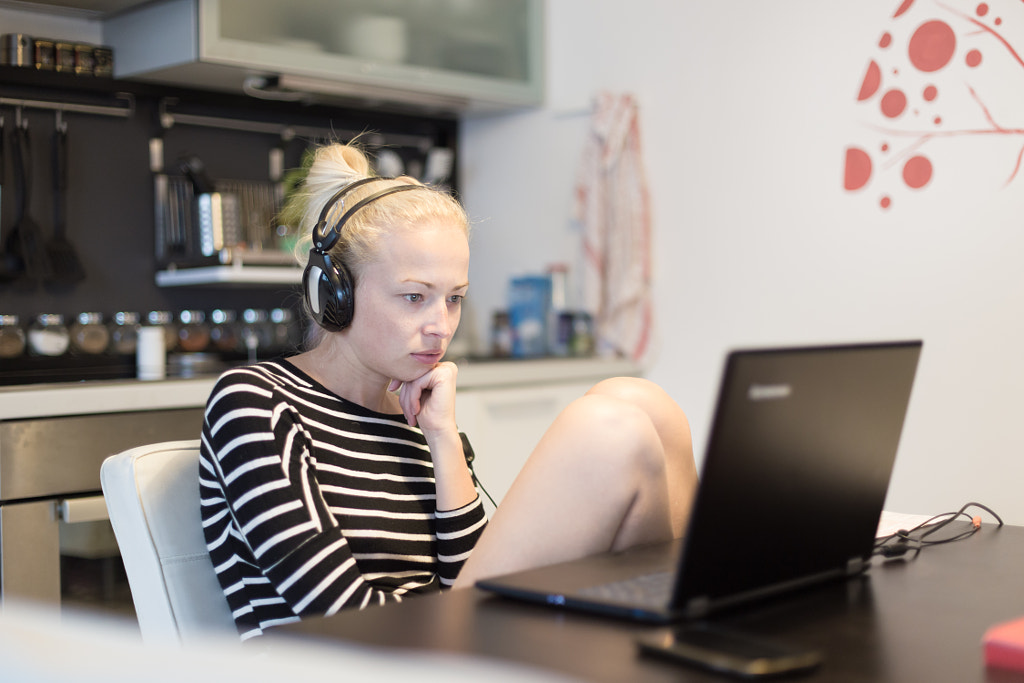 Adult woman in her casual home clothing working and studying remotely from her small flat late at... by Matej Kastelic on 500px.com