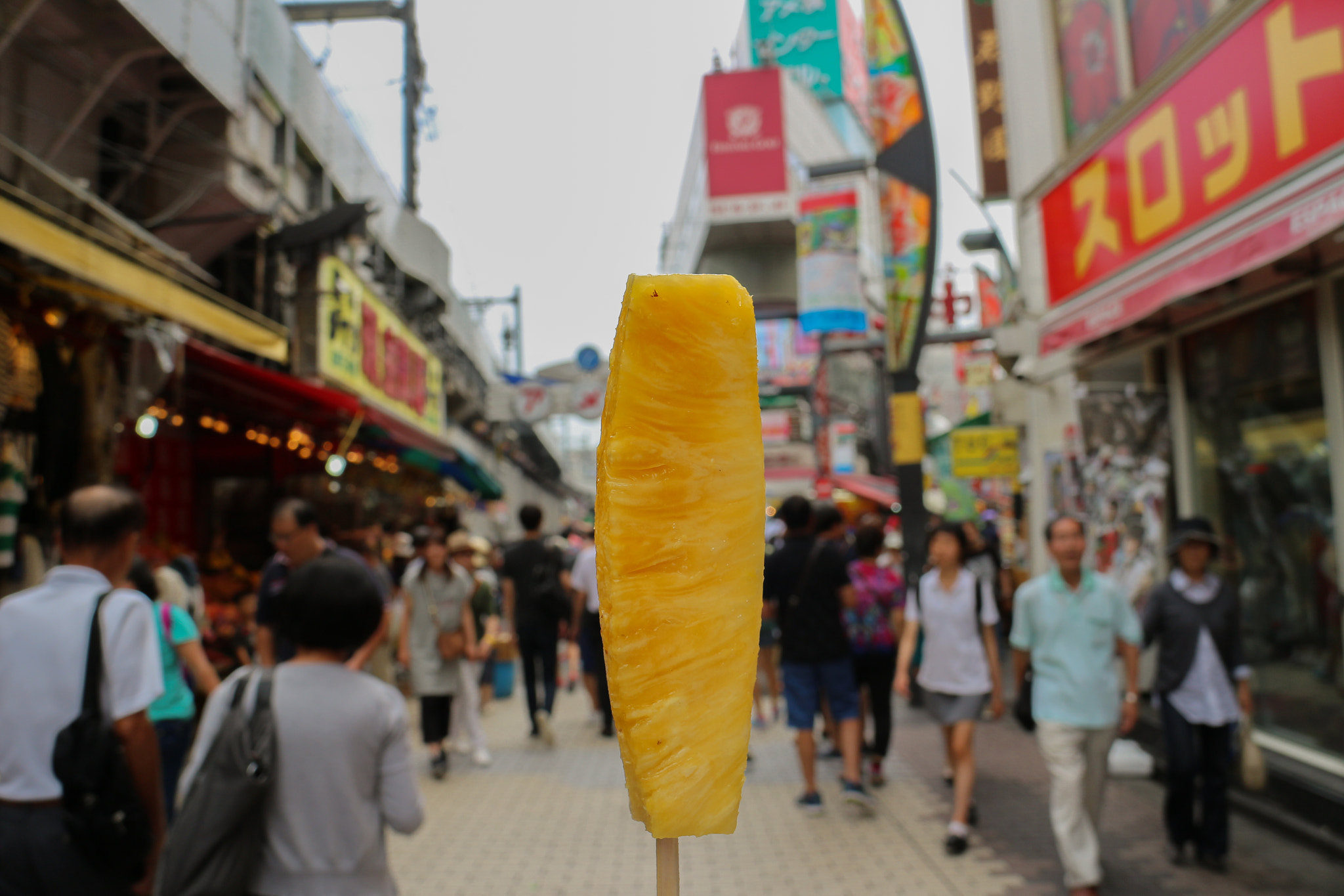 Canon EOS M2 sample photo. Pineapple standing in busy street photography