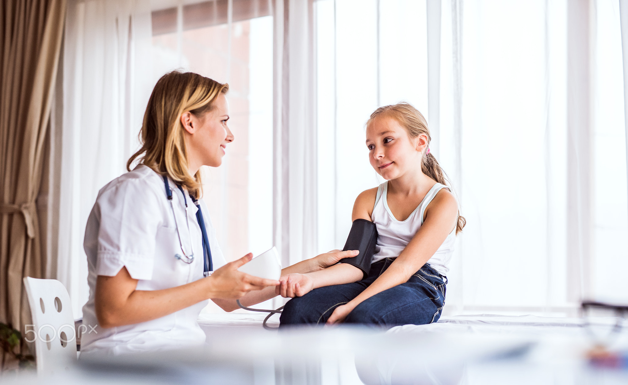 Young female doctor checking a small girl in her office.