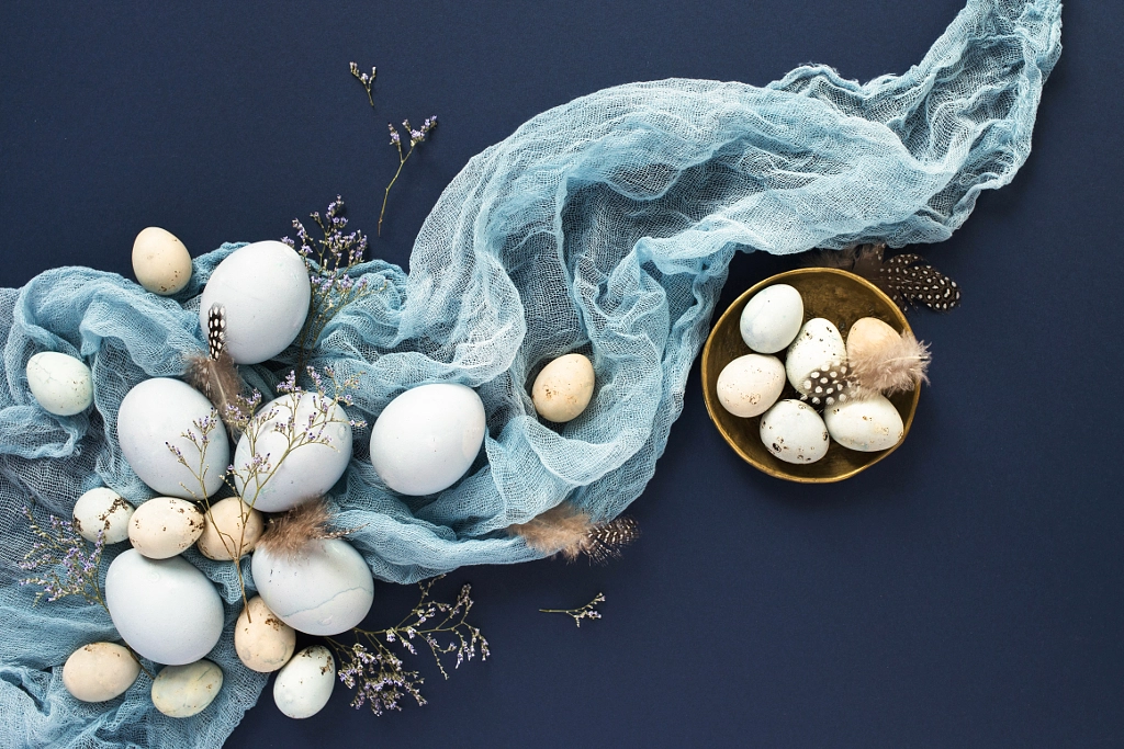 Easter background with blue painted eggs and napkin on dark blue by Olga Zarytska on 500px.com